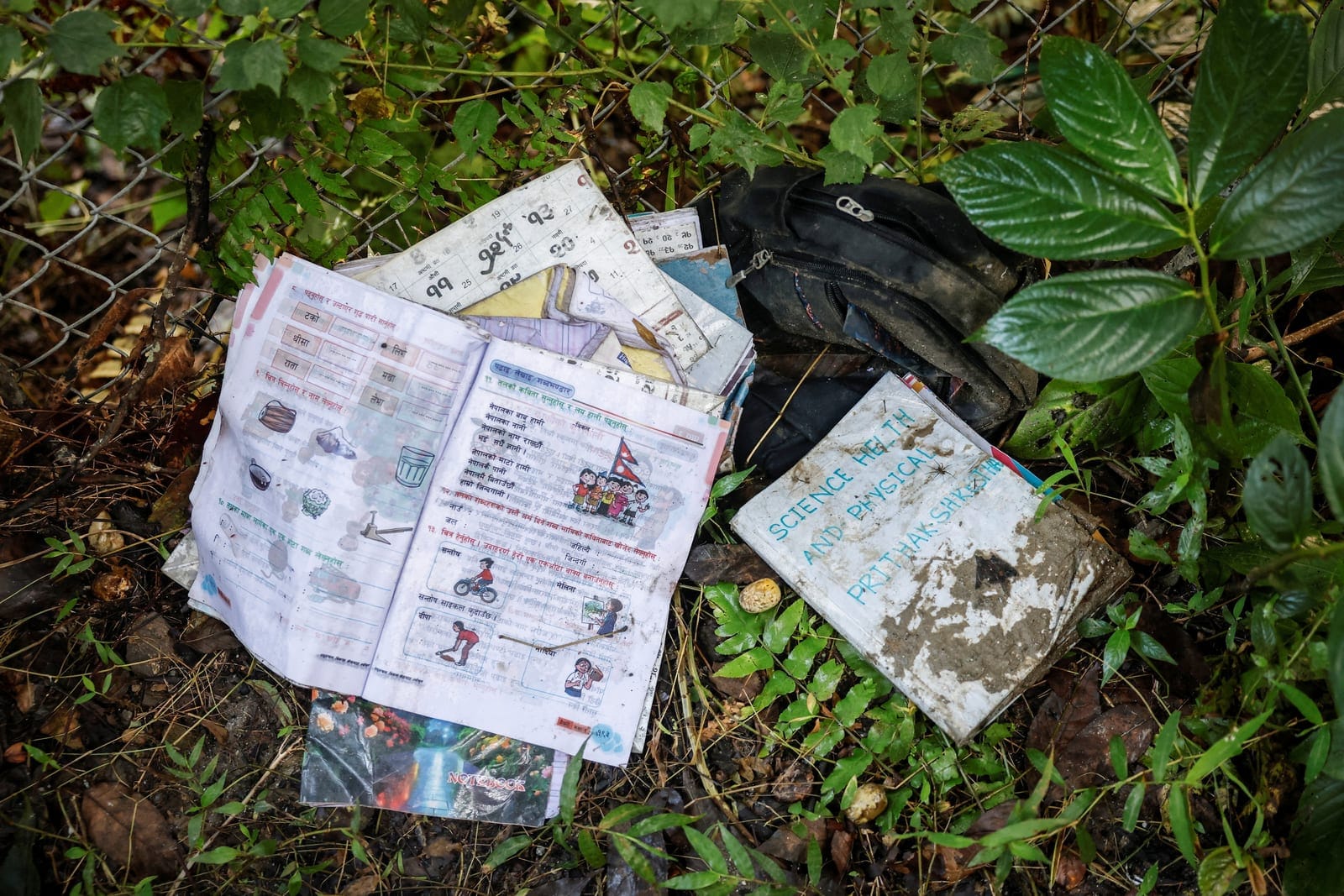 School books and a bag covered in sludge are pictured outside Uttargaya Public School following flash floods and mudslides in Angitar, Nuwakot district, Nepal, September 6, 2026. There are 5,130 people still reported missing on the Nepal side of the 