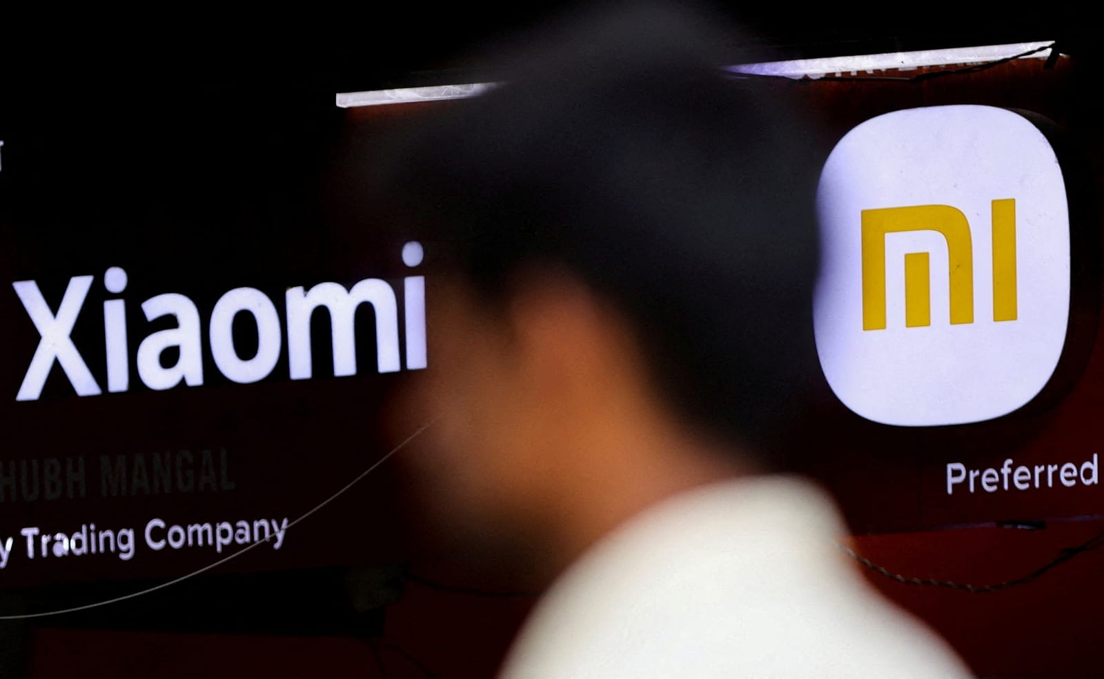 FILE PHOTO: A man walks past a logo of Xiaomi, a Chinese manufacturer of consumer electronics, outside a shop in Mumbai, India, May 11, 2022. REUTERS/Francis Mascarenha/File Photo