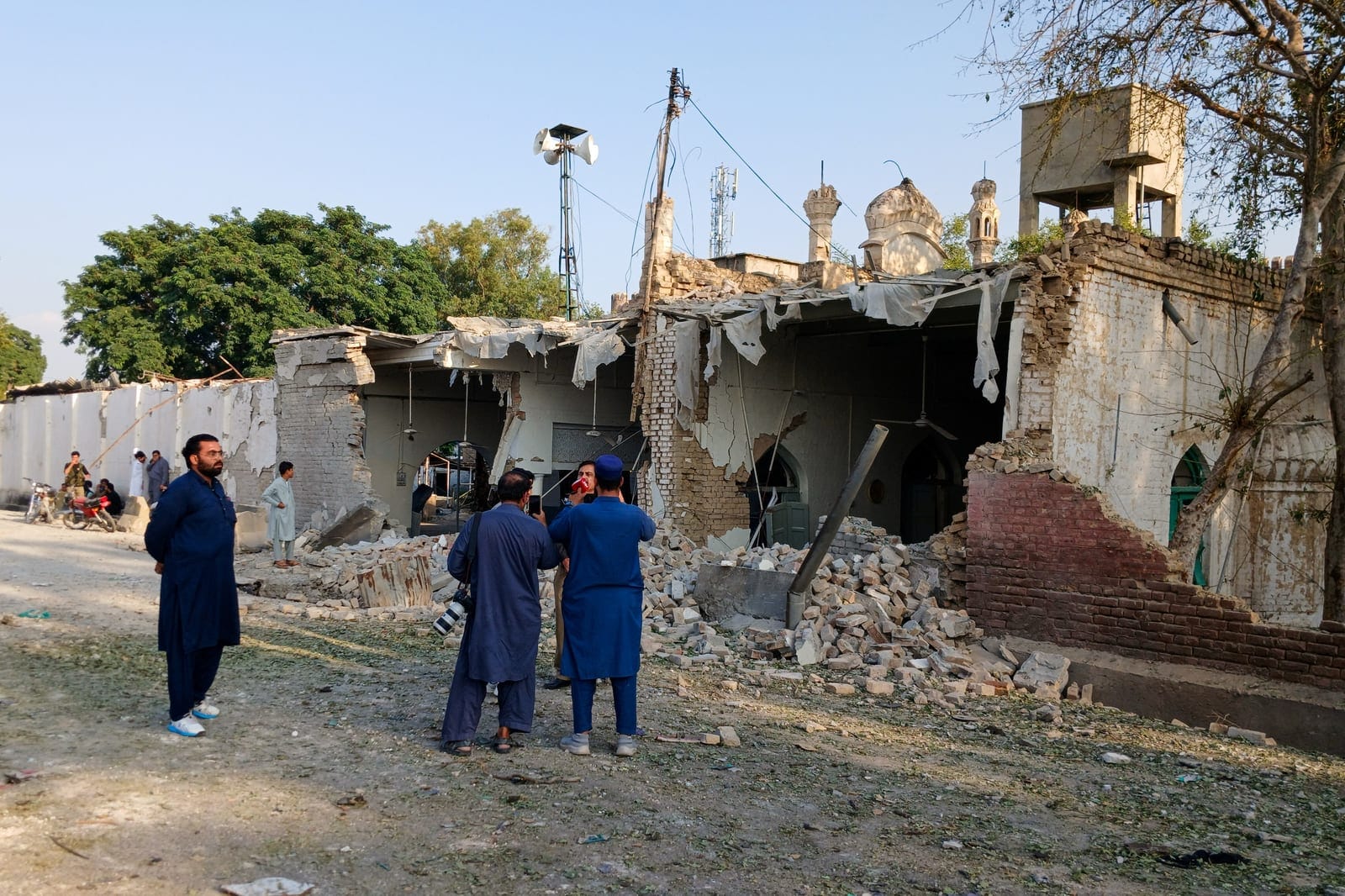 People stand near a damaged section of a police facility following a suicide attack in Kohat, Pakistan, September 18, 2026. REUTERS/Stringer