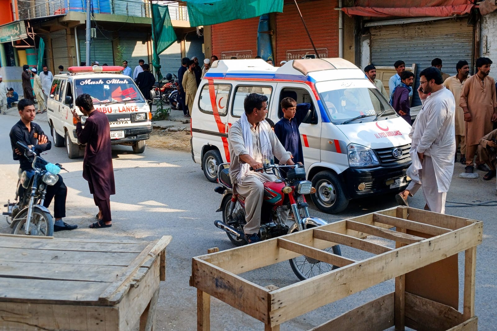 Ambulances and residents gather on a street leading to a police facility following a suicide attack in Kohat, Pakistan, September 18, 2026. REUTERS/Stringer