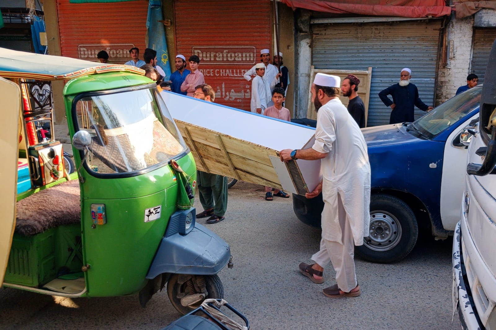 People carry an empty coffin box along a street leading to a police facility following a suicide attack at the facility in Kohat, Pakistan, September 18, 2026. REUTERS/Stringer