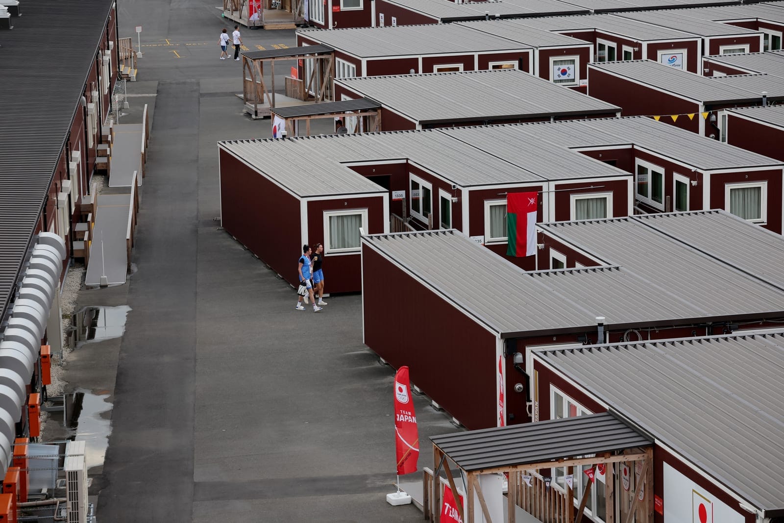 Asian Games - Aichi-Nagoya 2026 - Previews - Nagoya, Japan - September 18, 2026 General view of people outside wooden container units in the Athletes' Village ahead of the games REUTERS/Anushree Fadnavis