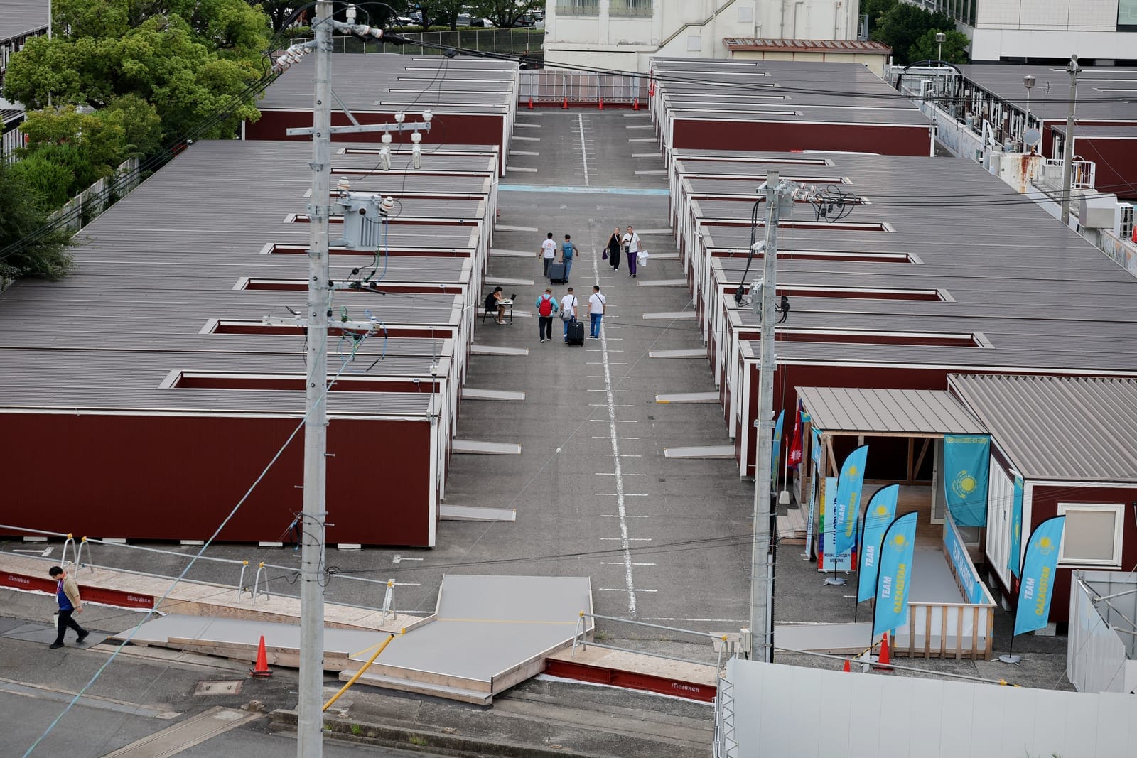 Asian Games - Aichi-Nagoya 2026 - Previews - Nagoya, Japan - September 18, 2026 General view of people outside wooden container units in the Athletes' Village ahead of the games REUTERS/Anushree Fadnavis
