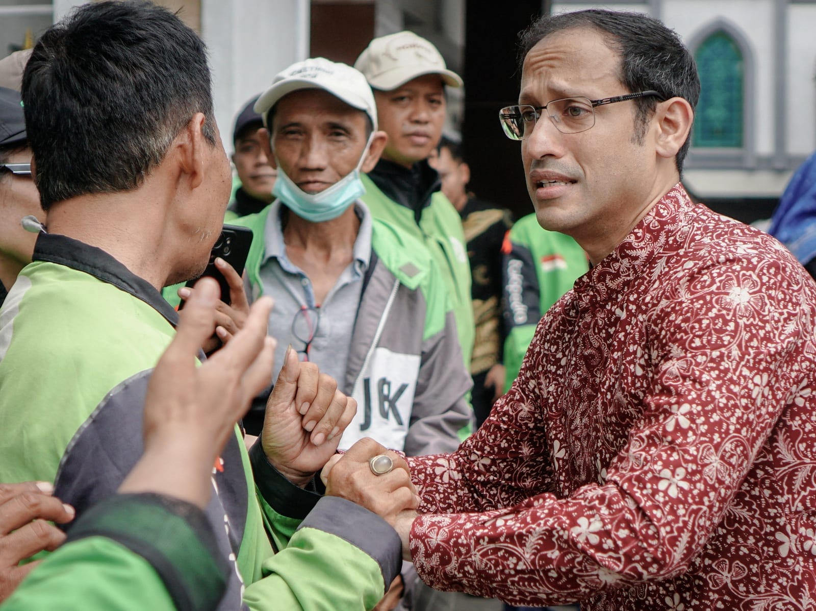 Nadiem Makarim, Indonesia's former education minister and co-founder of ride-hailing firm Gojek, greets Gojek’s drivers supporting him, after an appeal hearing for a graft conviction relating to improper laptop procurement, at the Central Jakarta Cou