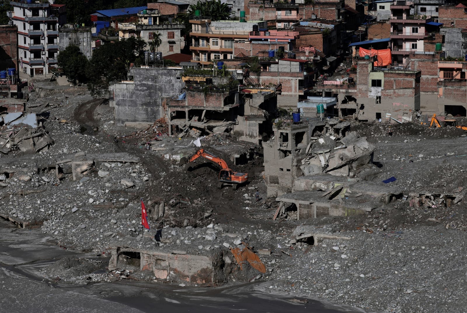 An excavator clears mud from damaged houses following deadly flash floods and a mudslide, in Nuwakot district, Nepal, September 21, 2026. REUTERS/Navesh Chitrakar