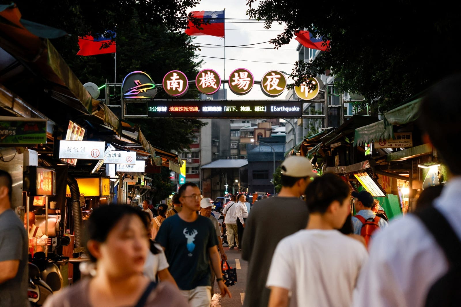People walk through Nanjichang Night Market beneath Taiwan flags in Taipei, Taiwan, September 24, 2026. REUTERS/Ann Wang