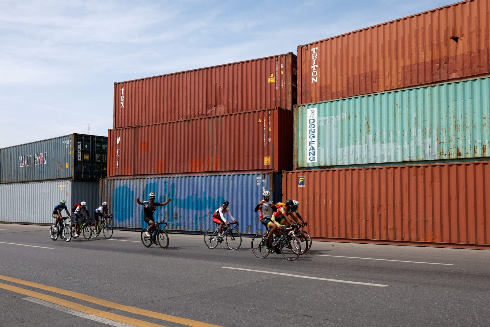 Cyclists ride past shipping containers used to block the roads ahead of a planned march by former Pakistani Prime Minister Imran Khan's party, PTI, at Peshawar Morr in Islamabad, Pakistan, September 25, 2026. REUTERS/Staff