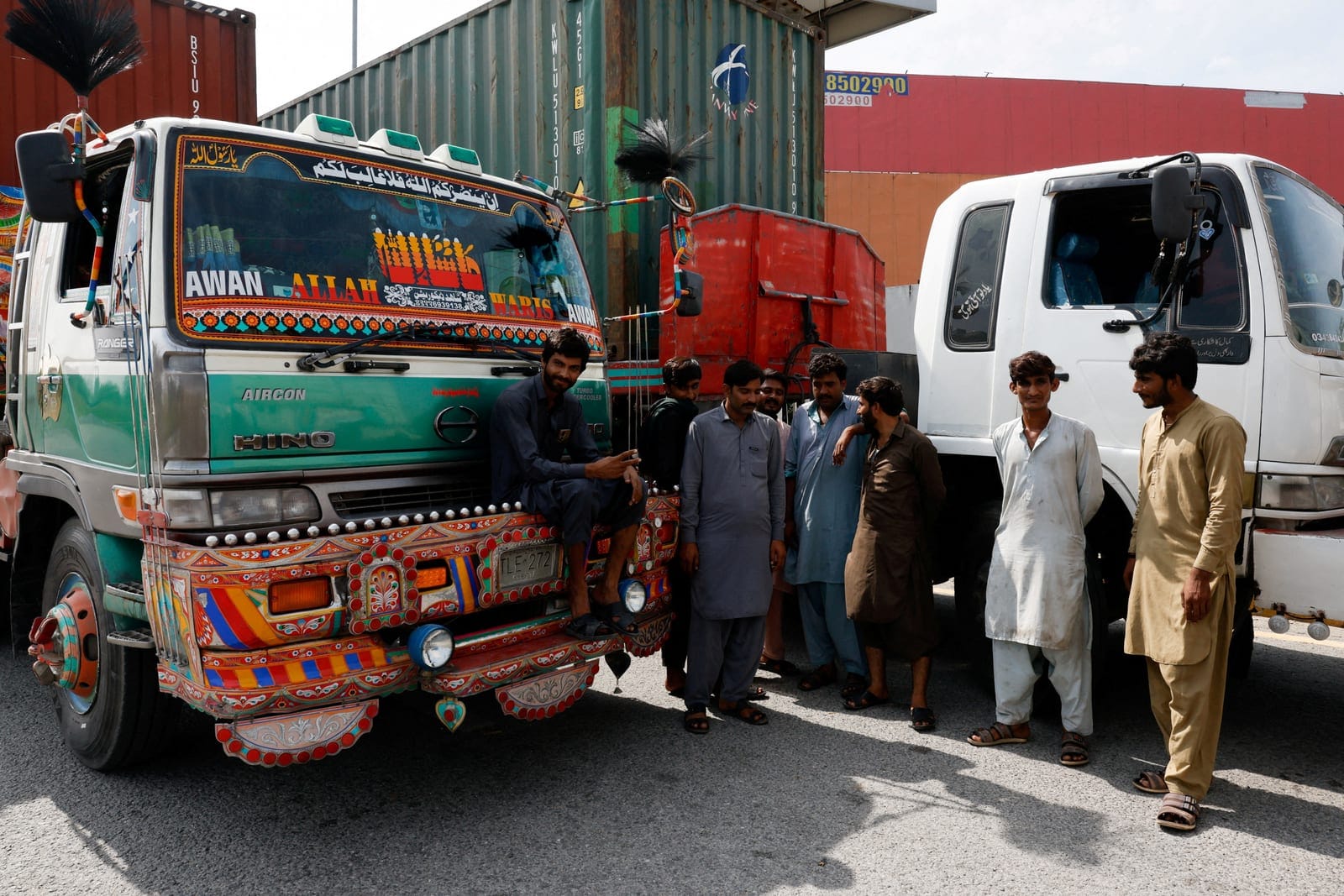 Drivers stand beside beside their trucks as the M-1 motorway is blocked by trailers after police closed the road ahead of a planned march by former Pakistani Prime Minister Imran Khan's party, PTI, from Peshawar to the capital, Islamabad, Pakistan, S
