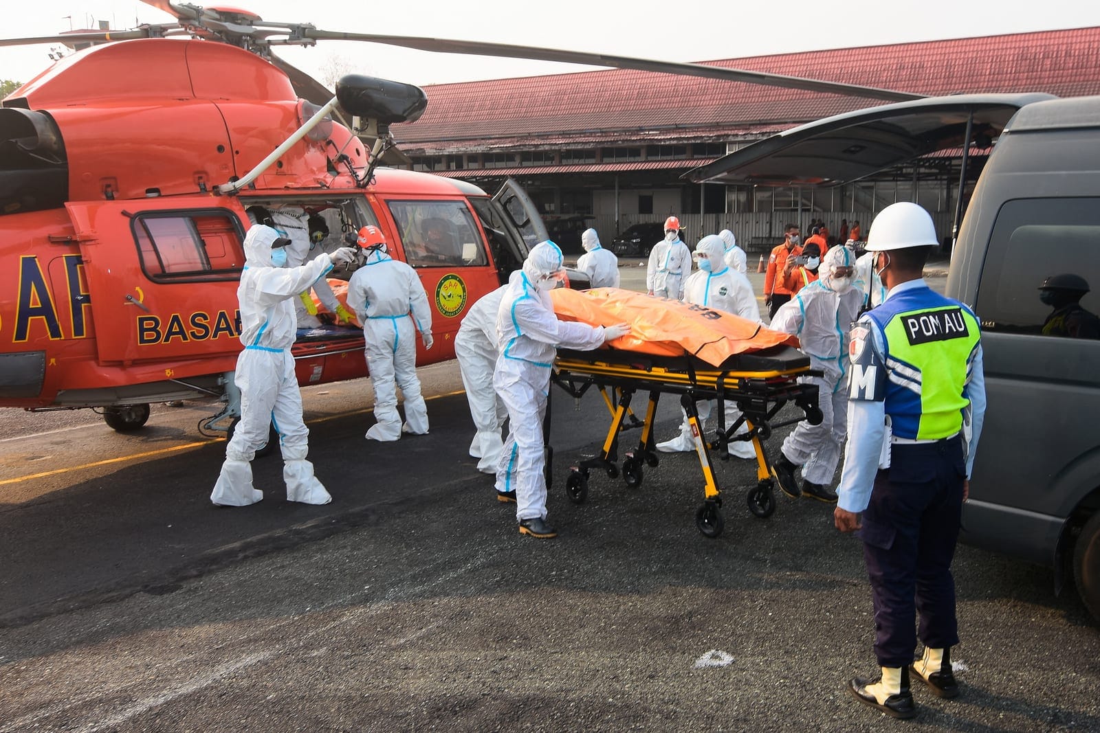 Rescuers in protective suits move a body bag of a victim recovered from the Virgo Transport 8 ferry, which capsized in the Java Sea while sailing from Surabaya in East Java to Banjarmasin in South Kalimantan, to be transported to hospital for identif