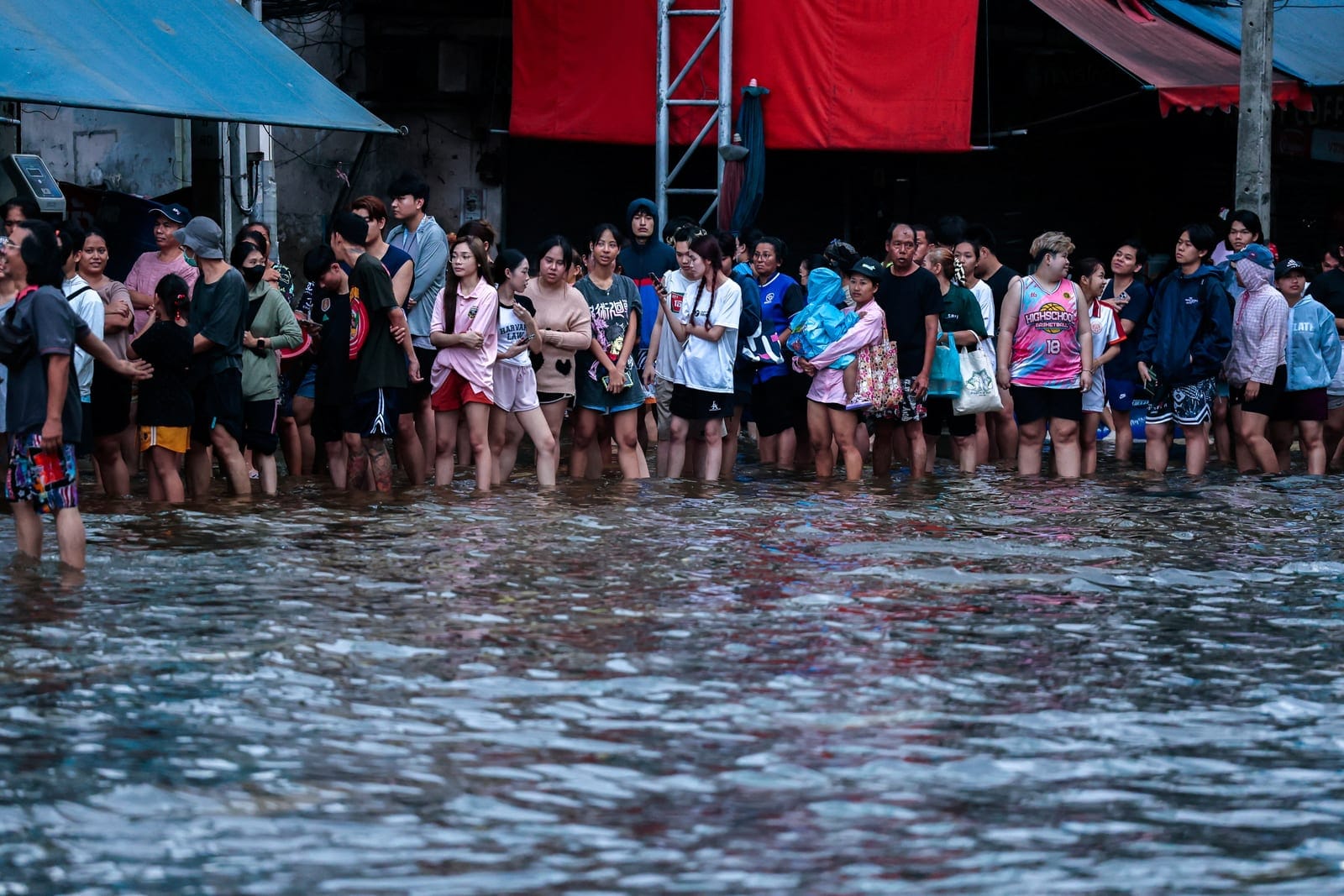 People queue for food in a flooded area following heavy rain in Bangkok, Thailand, September 28, 2026. REUTERS/Patipat Janthong