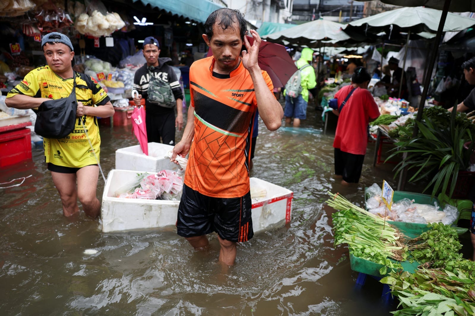 People navigate through a flooded market in Bangkok, Thailand, September 28, 2026. REUTERS/Athit Perawongmetha