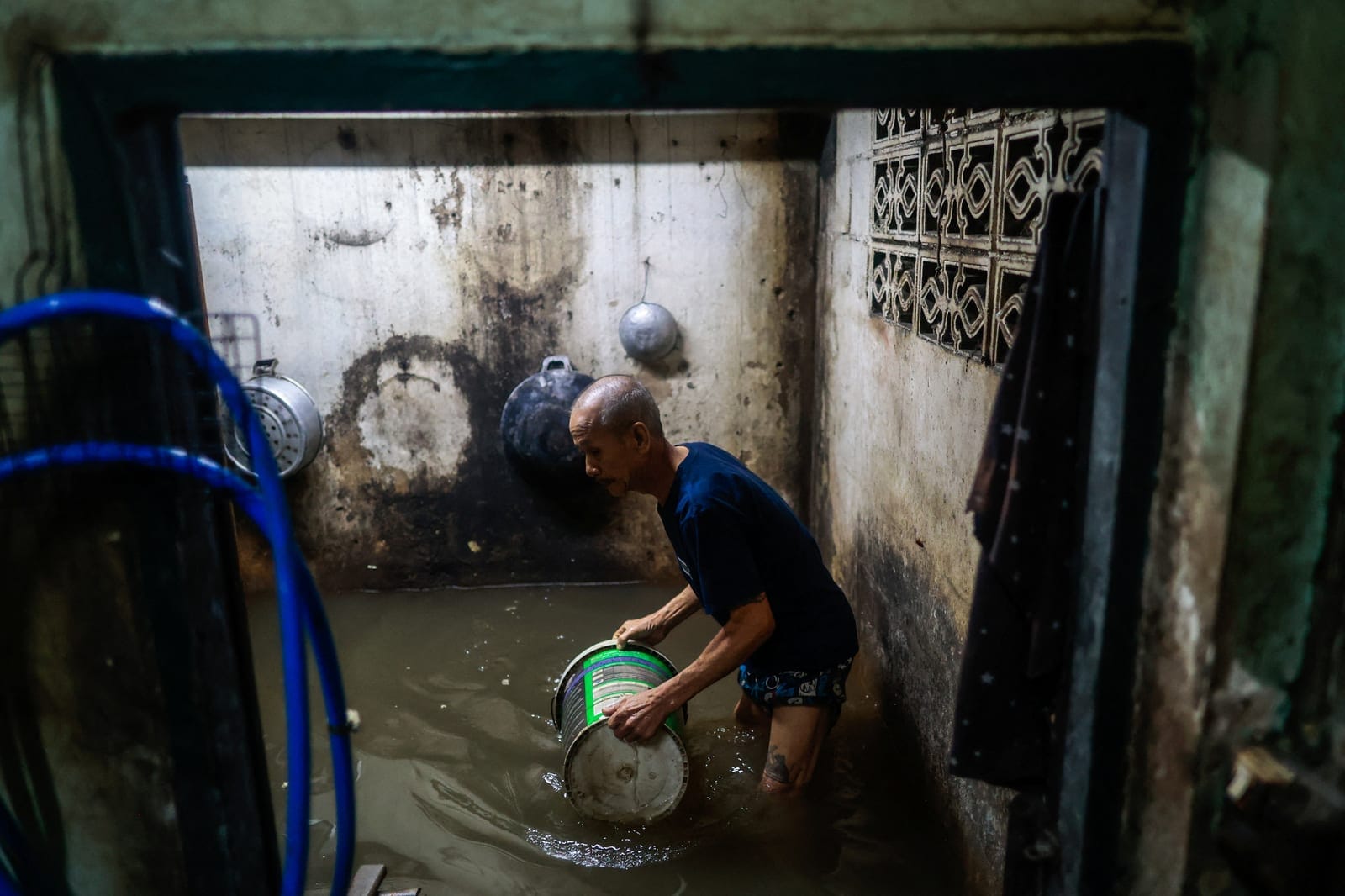 Chuchok Inyu, 68, uses a plastic bucket to bail floodwater out of his house in Bangkok, Thailand, September 28, 2026. REUTERS/Patipat Janthong