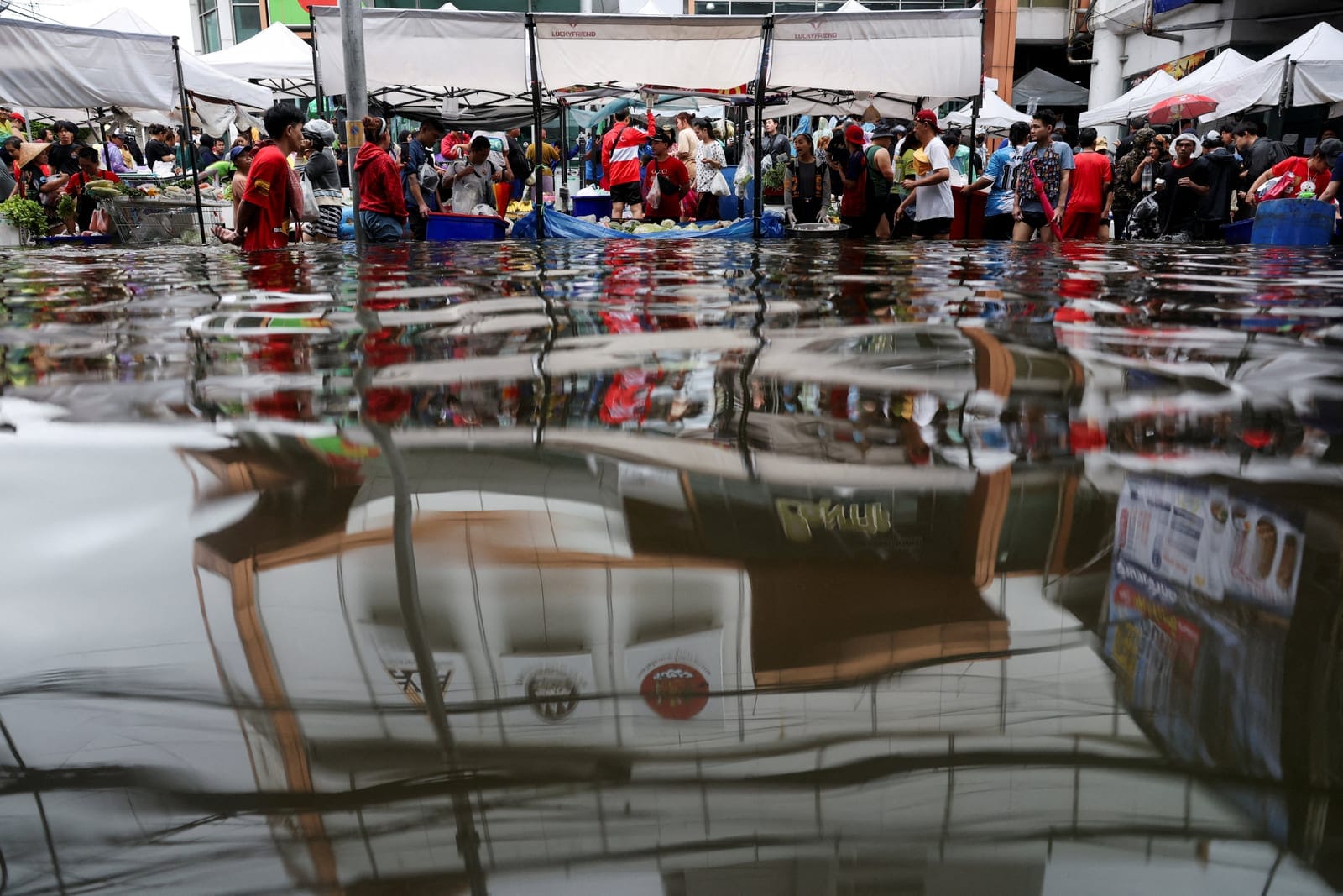 People navigate through a flooded market in Bangkok, Thailand, September 28, 2026. REUTERS/Athit Perawongmetha