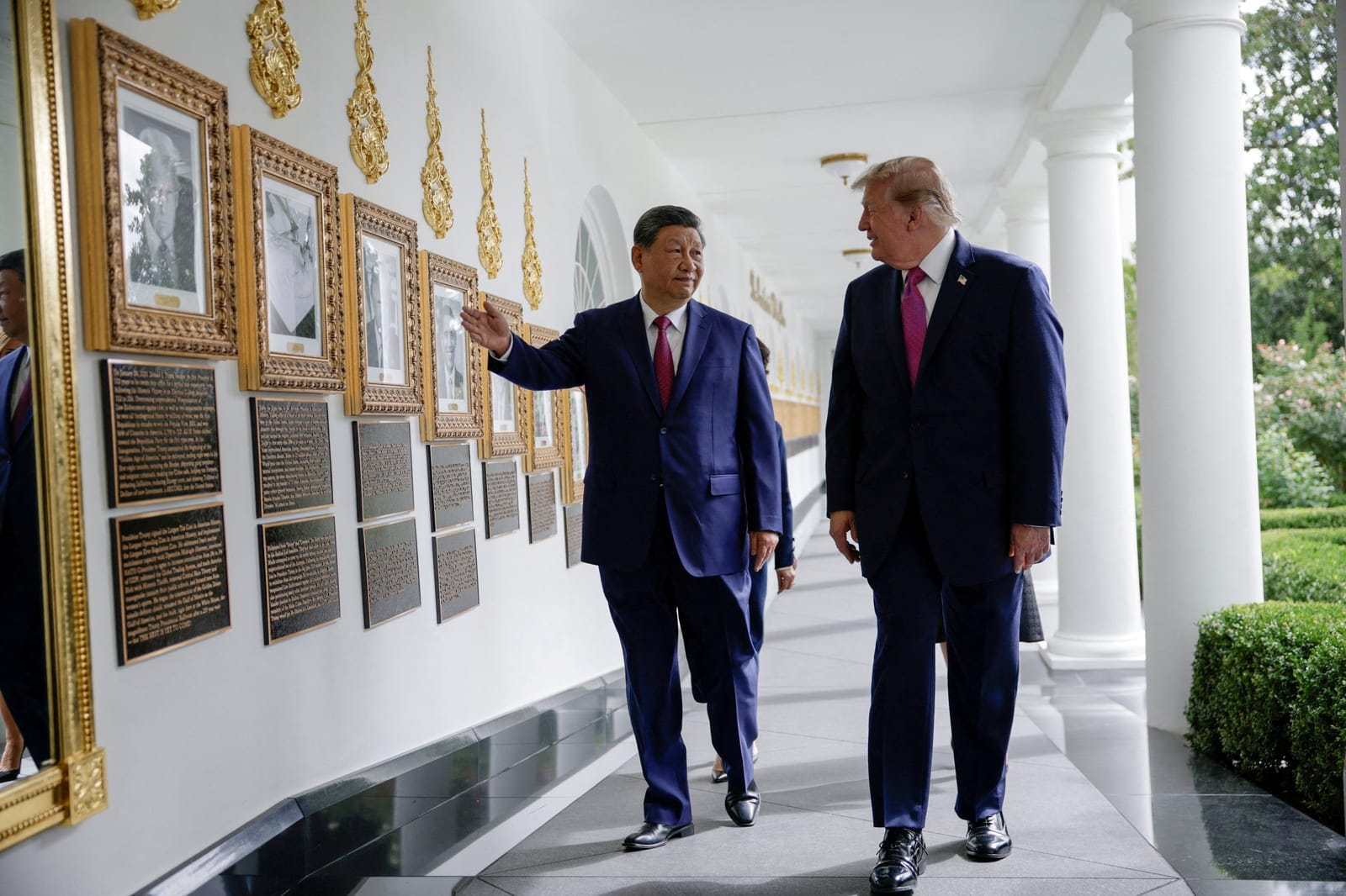 FILE PHOTO: US President Donald Trump and Chinese President Xi Jinping walk past an image of an autopen signing former U.S. President Joe Biden's signature at the "Presidential Walk of Fame" in the Colonnade of the White House in Washington, D.C., US