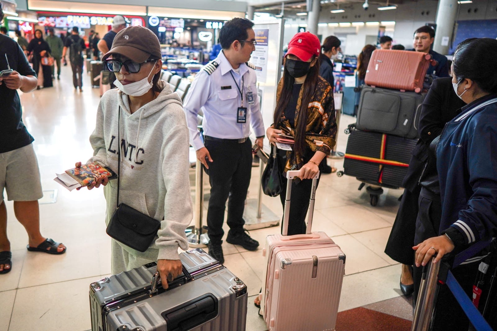 Passengers walk with baggage claimed from Thai Airways flights at Suvarnabhumi International Airport, after heavy rain and flooding disrupted the airline's ground operations, in Bangkok, Thailand, September 29, 2026. REUTERS/Athit Perawongmetha