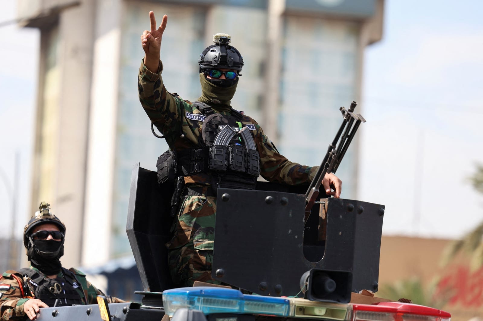 A member of the Iraqi security forces gestures as they drive in a convoy through the city as they celebrate the withdrawal of US-led coalition forces from Iraq, ending a military presence that began after the 2003 US-led invasion, in Baghdad, Iraq, S