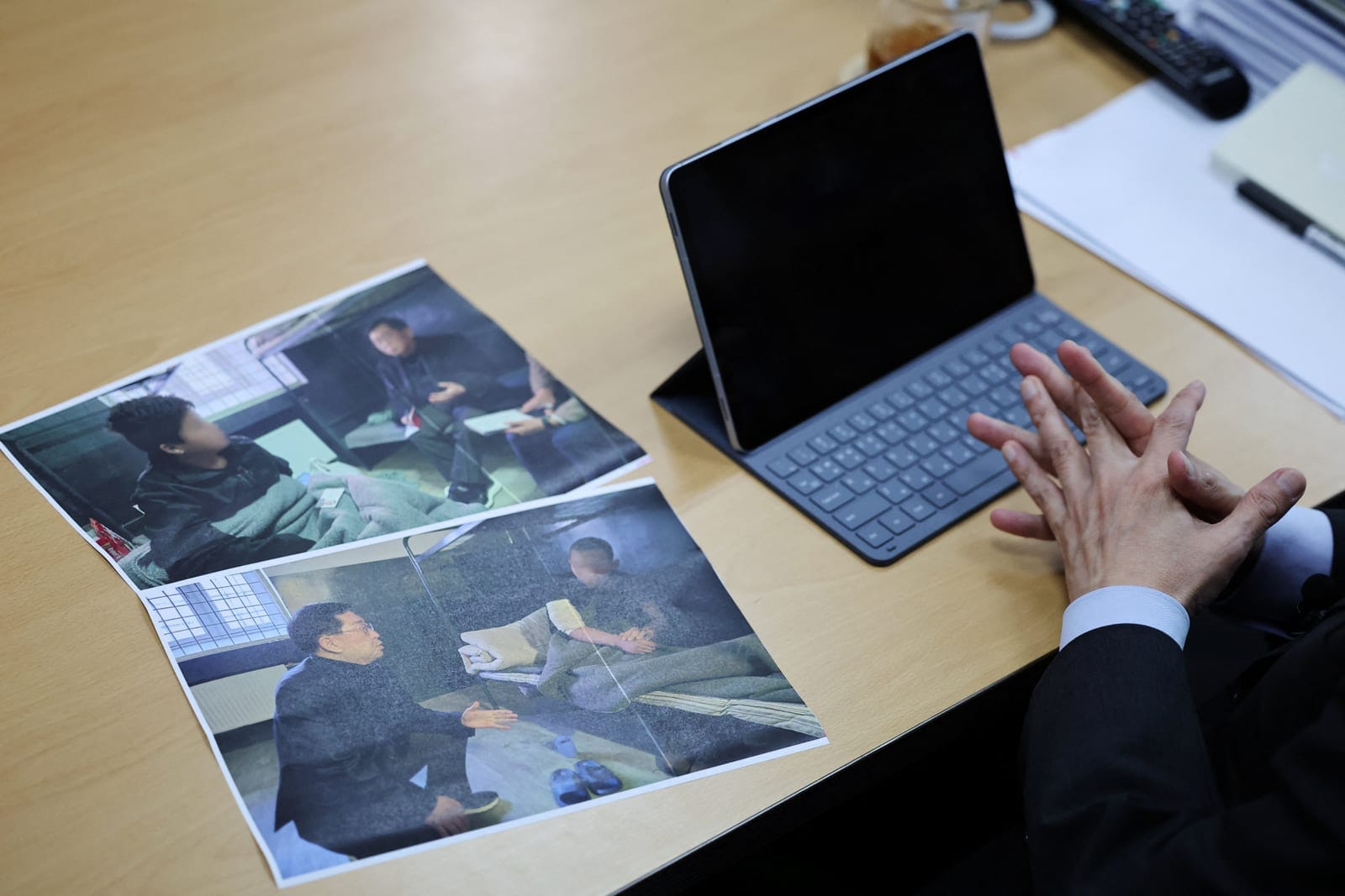Lawmaker Yu Yong-weon of South Korea’s main opposition People Power Party explains pictures, showing two North Korean POWs who were recently transferred from Ukraine to South Korea, taken during his visit to a POW camp in Ukraine last February, at hi