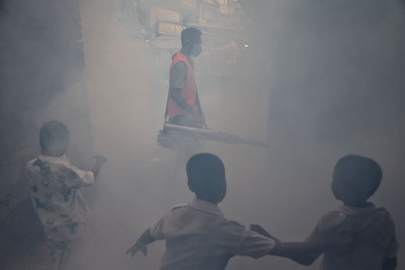 A man fumigates a road as a preventive measure against mosquito-borne diseases, particularly dengue, in Dhaka