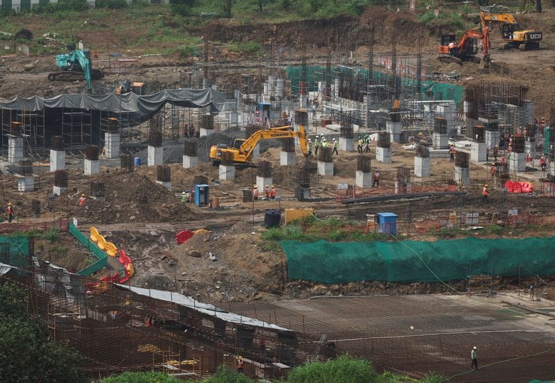 Workers and excavators at the site of an Amazon data centre in Thane