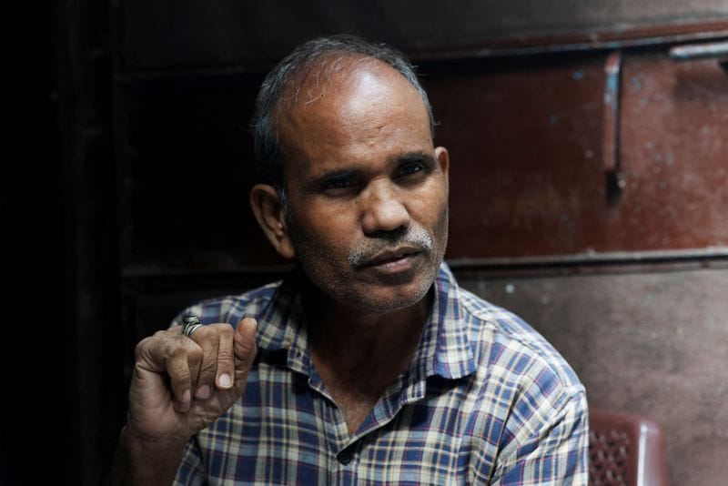 Kamta Prasad, a voter who is listed as "Kanta Prasad" and is declared dead in the SIR list, gets ready before leaving for work, in New Delhi