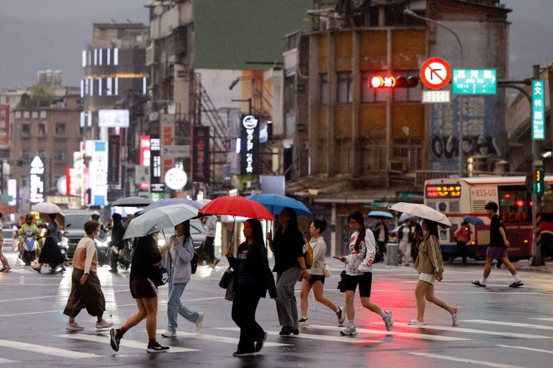 People carry umbrellas on a rainy day as Typhoon Champi approaches, in Taipei
