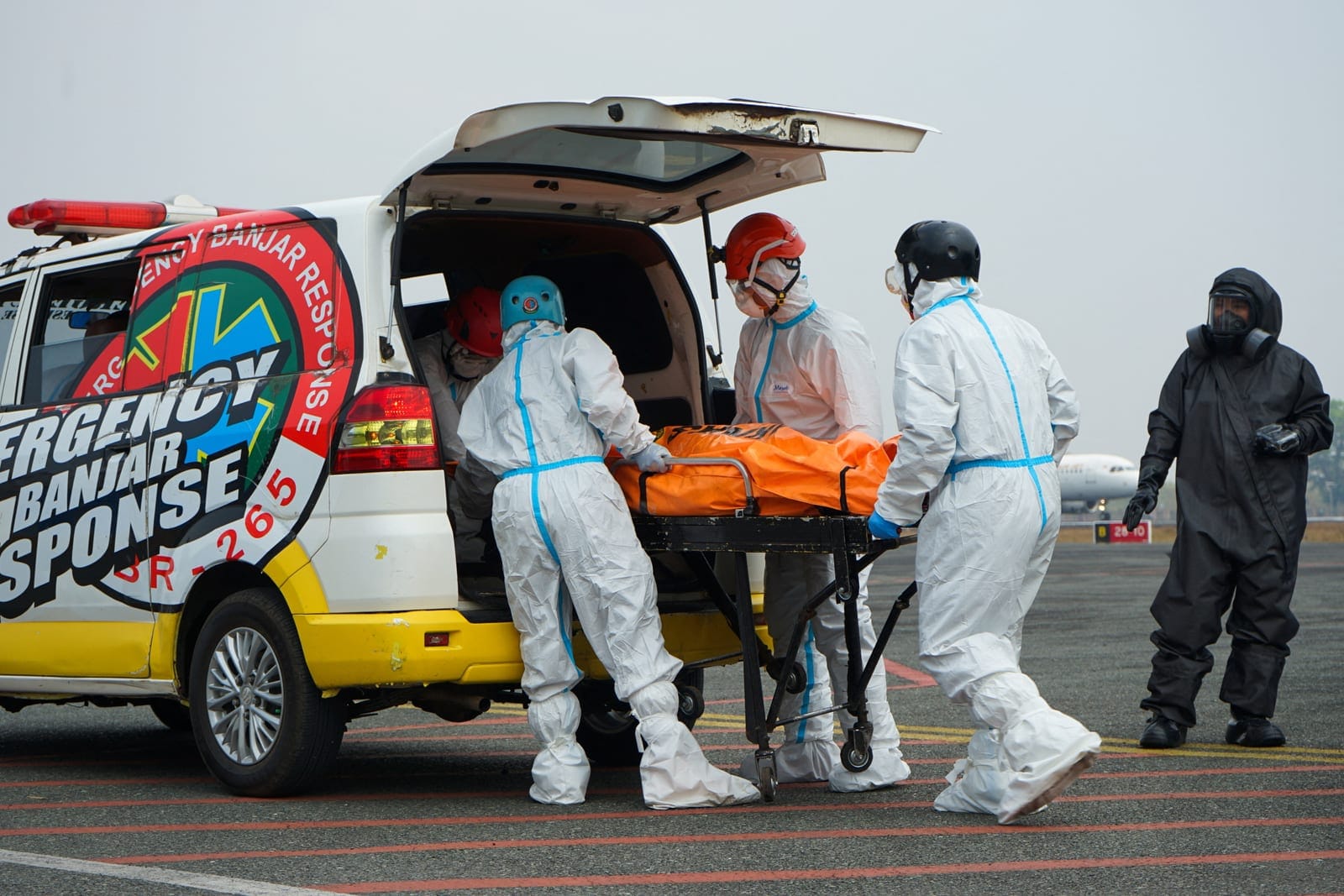 Rescuers in hazmat suits move a body bag of a victim to an ambulance, recovered from the Virgo Transport 8 ferry, which capsized in the Java Sea while sailing from Surabaya in East Java to Banjarmasin in South Kalimantan, to be transported to the hos