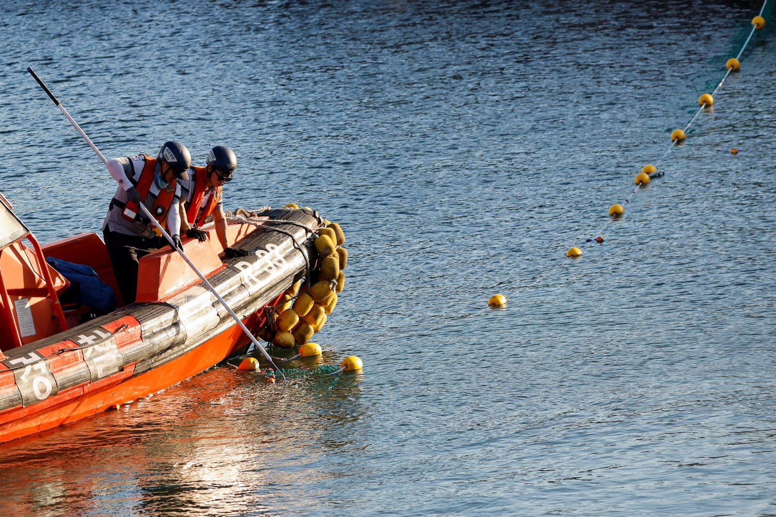Rescue workers aboard a boat adjust a net during an operation to guide a shark nicknamed "Bukangi" out of a canal at the North Port in Busan, South Korea, October 2, 2026. REUTERS/Kim Soo-hyeon