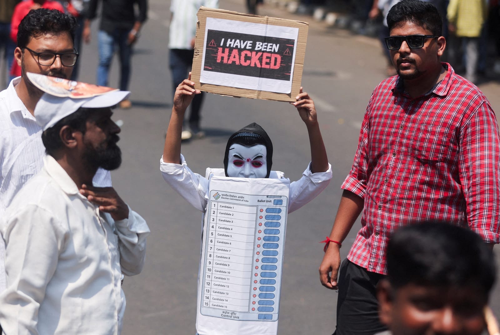 A supporter dressed as an electronic voting machine (EVM) holds a placard during a protest demanding the resignation of India's Chief Election Commissioner Gyanesh Kumar organised by the Shiv Sena (UBT) and the Maharashtra Navnirman Sena (MNS) in Mum