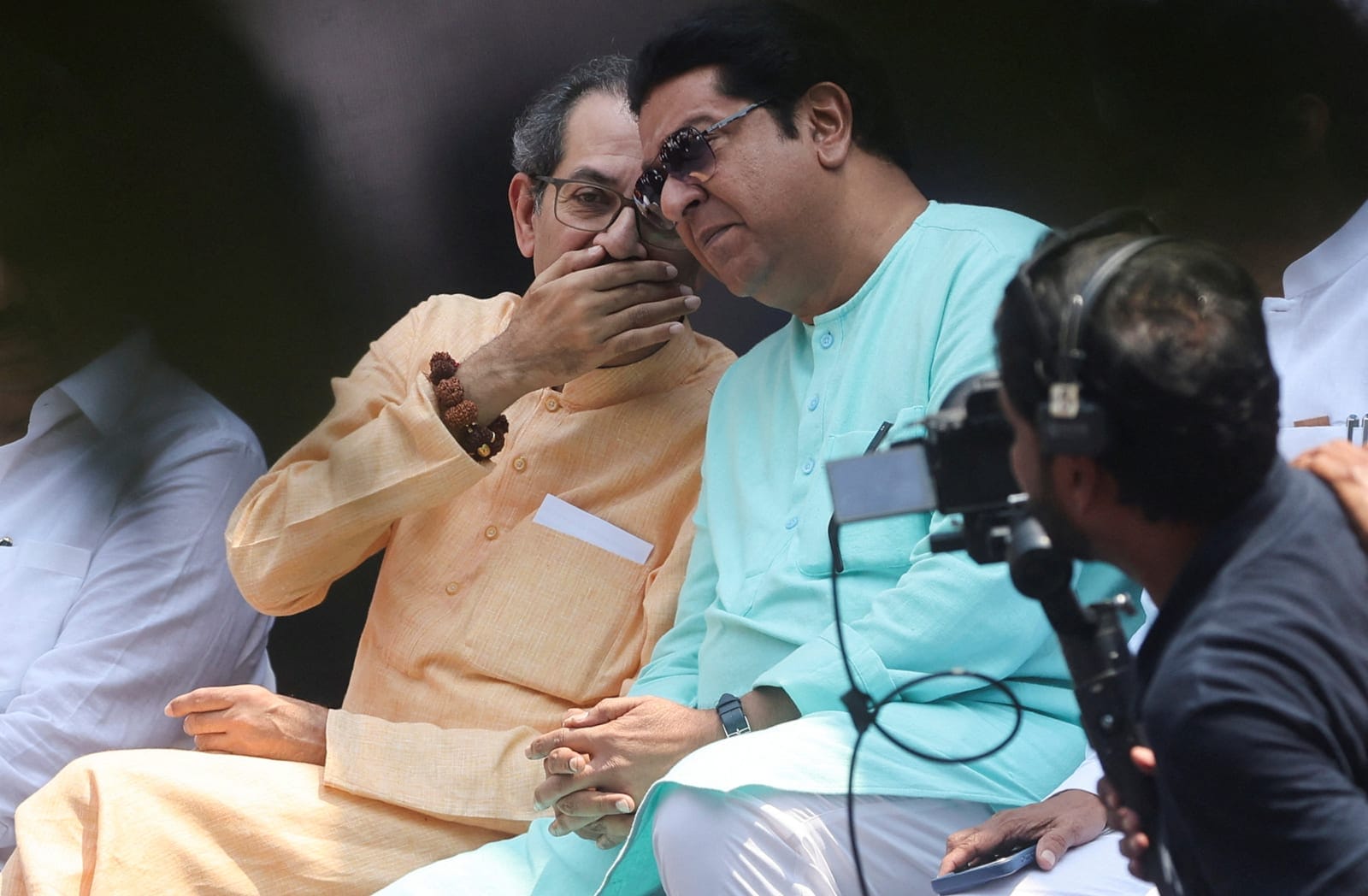 Uddhav Thackeray, president of Shiv Sena (UBT), speaks with Raj Thackeray, president of the Maharashtra Navnirman Sena (MNS), during a protest demanding the resignation of India's Chief Election Commissioner Gyanesh Kumar organised by the Shiv Sena (