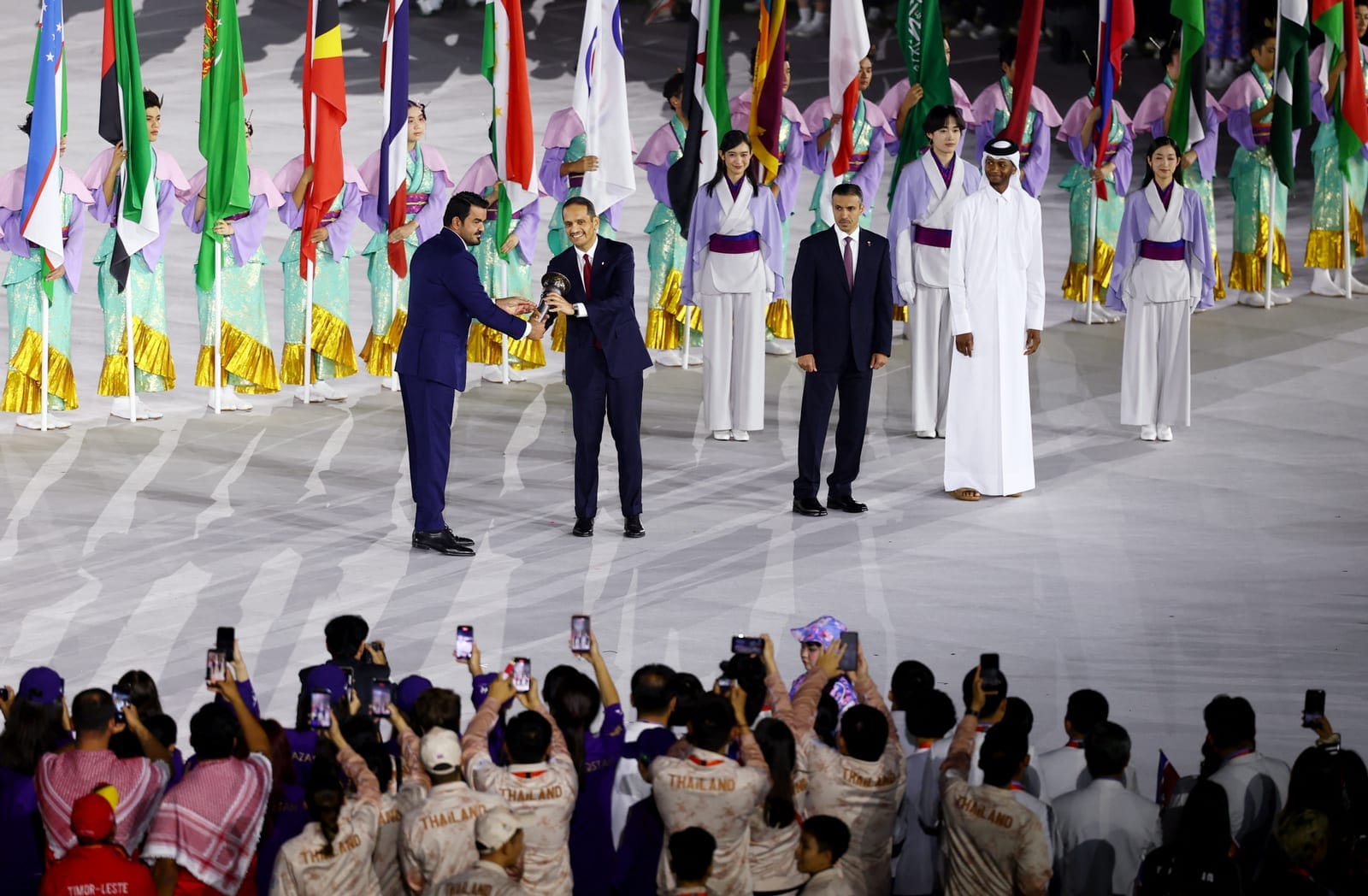 Asian Games - Aichi-Nagoya 2026 - Closing Ceremony - Paloma Mizuho Stadium, Nagoya, Japan - October 4, 2026 OCA president Sheikh Joaan bin Hamad Al Thani passes on the torch of the first Asian Games to Qatar's Prime Minister Sheikh Mohammed bin Abdul