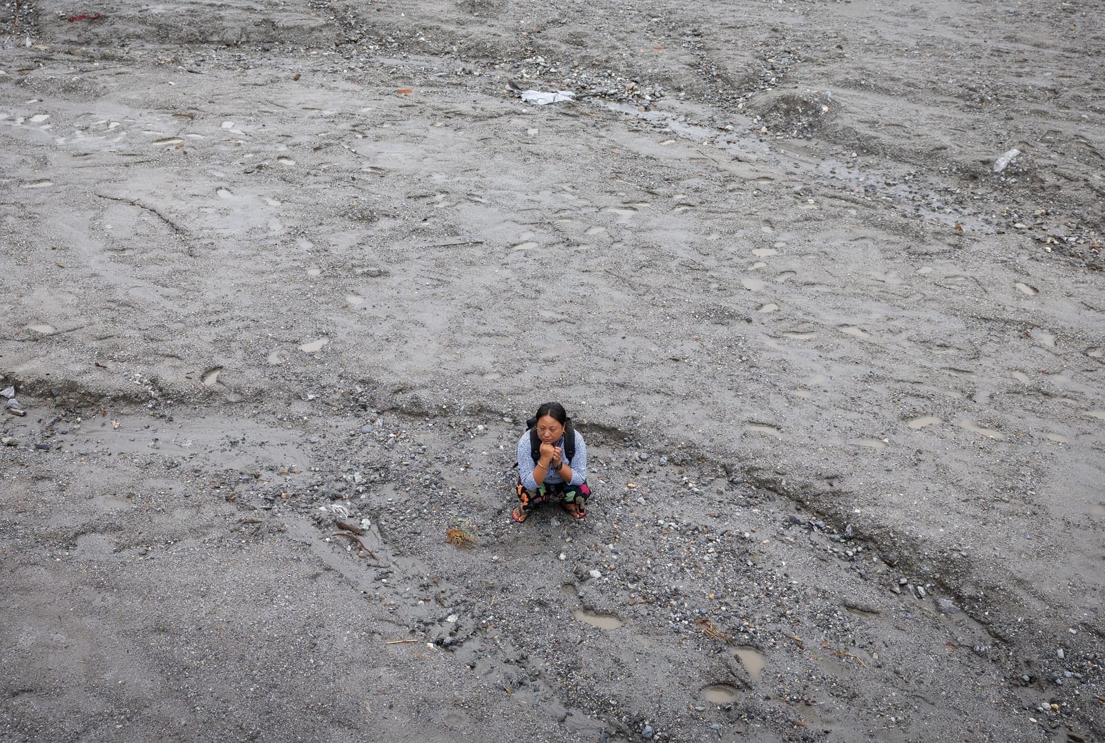 Kalpana Thapa Magar, 43, displaced by recent flash floods and mudslides, poses for a photograph on the sludge that buried her home in Betrawati, Nuwakot district, Nepal, September 9, 2026. REUTERS/Adnan Abidi