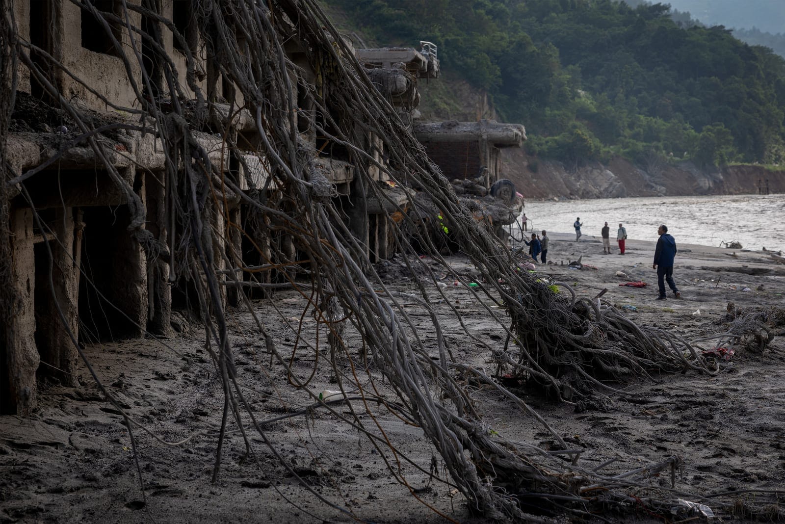 People stand in front of the damaged houses following the deadly flash floods and mudslide, at Devighat, Nuwakot district, Nepal, September 8, 2026. REUTERS/Adnan Abidi