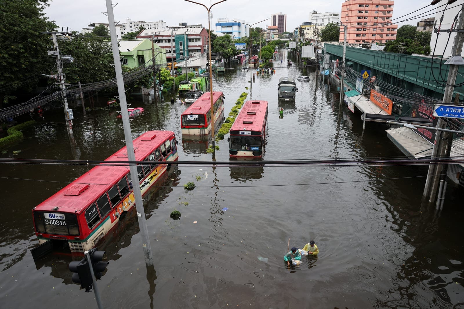 People navigate next to stranded buses in a flooded area in Bangkok, Thailand, September 28, 2026. REUTERS/Athit Perawongmetha