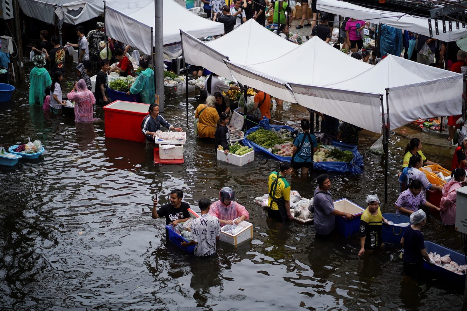 People navigate through a flooded market in Bangkok, Thailand, September 28, 2026. REUTERS/Athit Perawongmetha