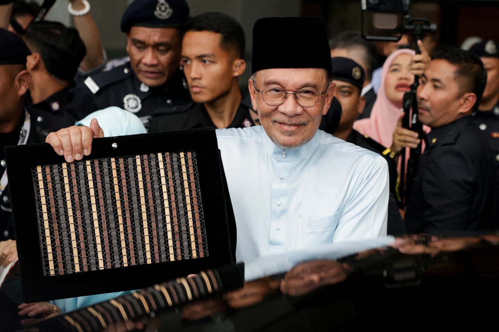 Malaysia's Prime Minister and Finance Minister Anwar Ibrahim holds the 2027 national budget document at the Finance Ministry building as he departs for Parliament to table the budget, in Putrajaya, Malaysia, October 9, 2026. REUTERS/Hasnoor Hussain
