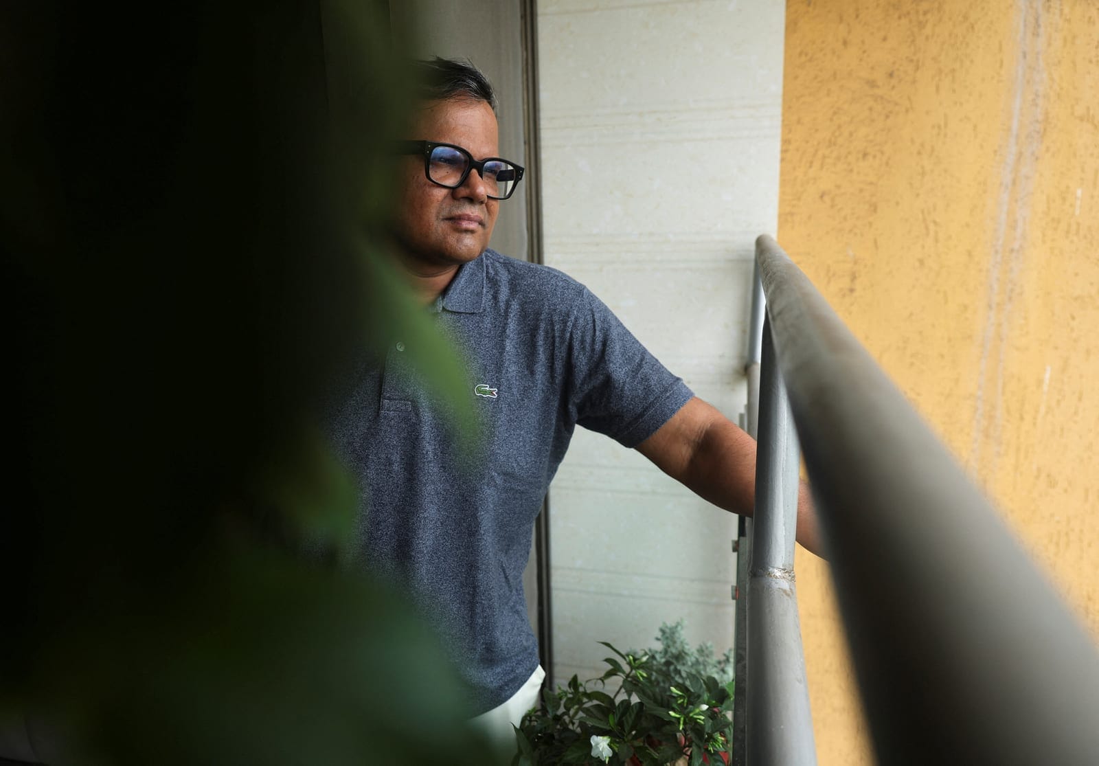 Tushar Shetty, a resident of the Lodha Luxuria residential complex, looks towards the site of an Amazon data centre from the balcony of his home in Thane, India, September 22, 2026. REUTERS/Francis Mascarenhas