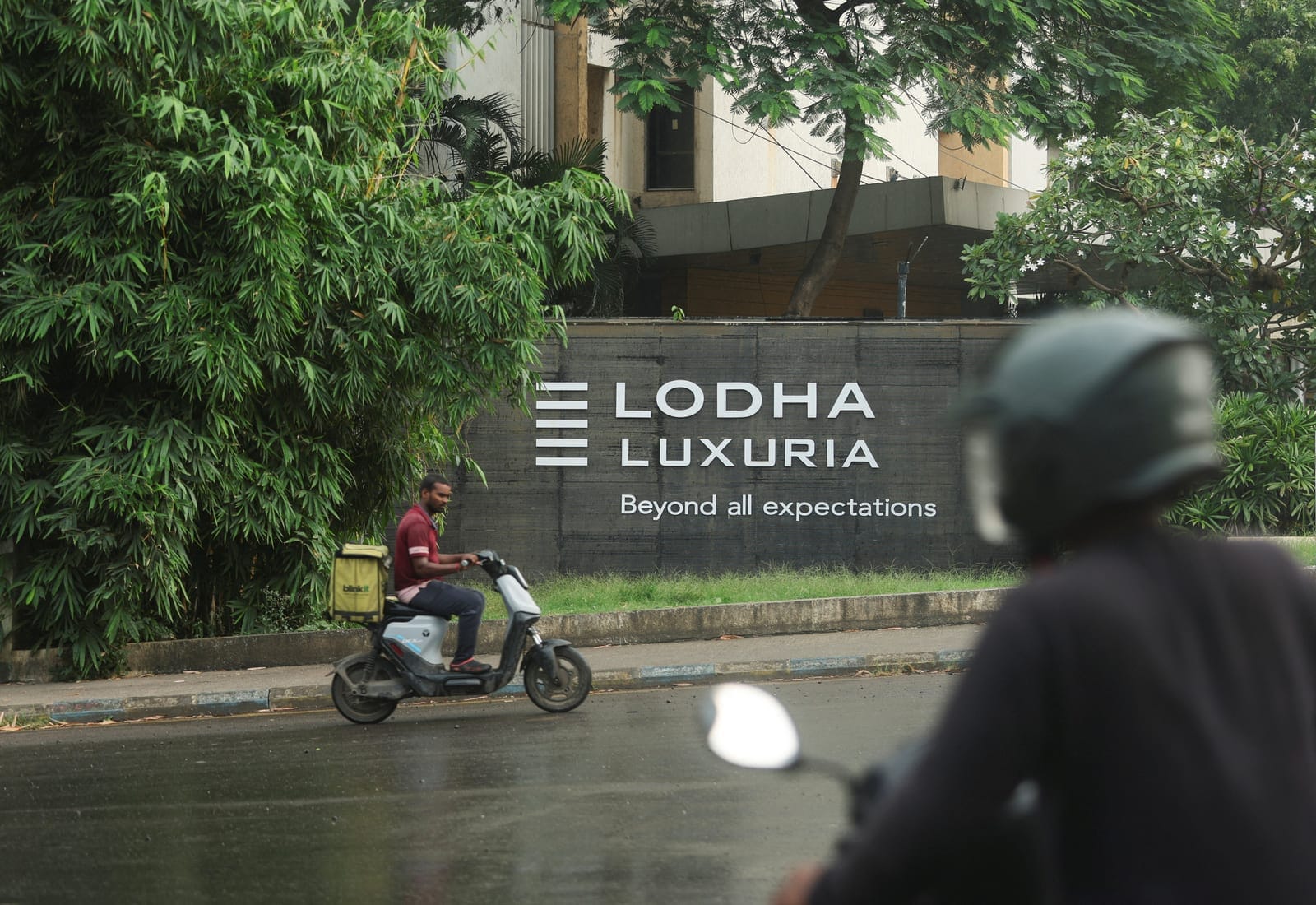A person rides past Lodha Luxuria residential towers near the construction site of an Amazon data centre in Thane, India, September 30, 2026. REUTERS/Francis Mascarenhas