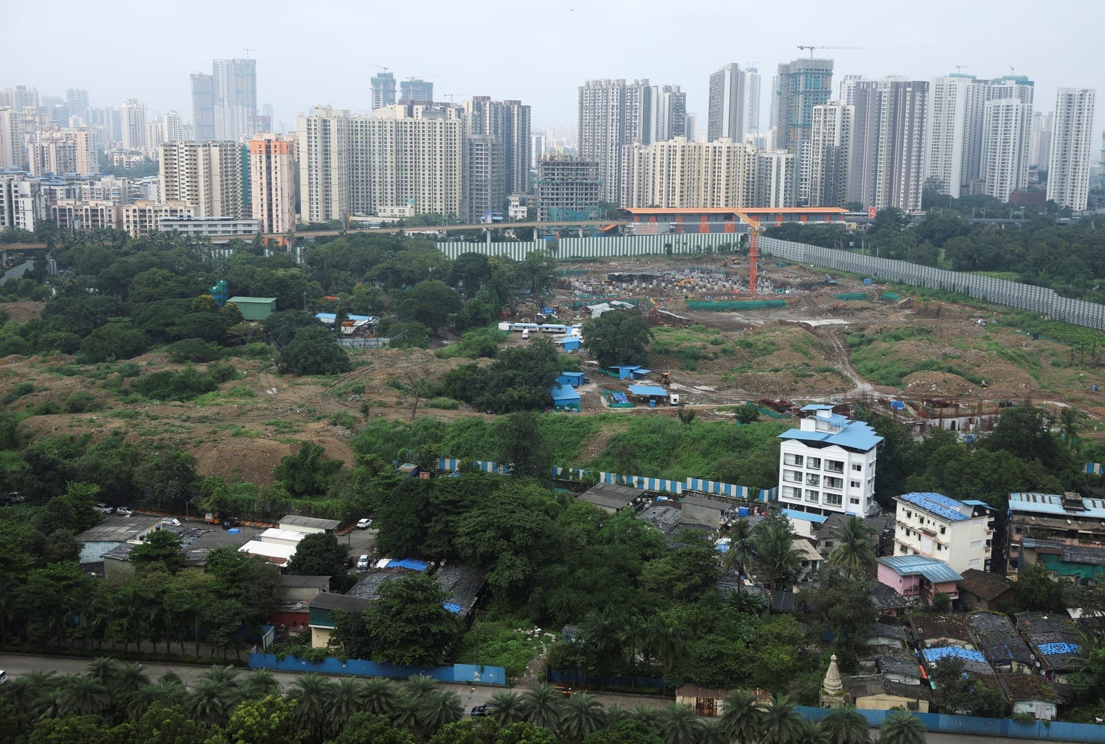 Residential homes and high-rise buildings stand along the boundary of the site of an Amazon data centre in Thane, India, September 22, 2026. REUTERS/Francis Mascarenhas