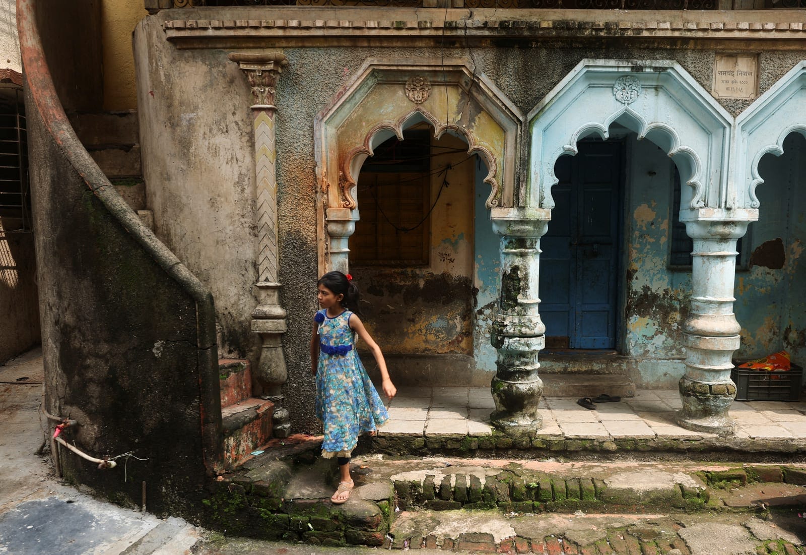 A girl walks past a house in a residential area near the site of an Amazon data centre in Thane, India, September 22, 2026. REUTERS/Francis Mascarenhas