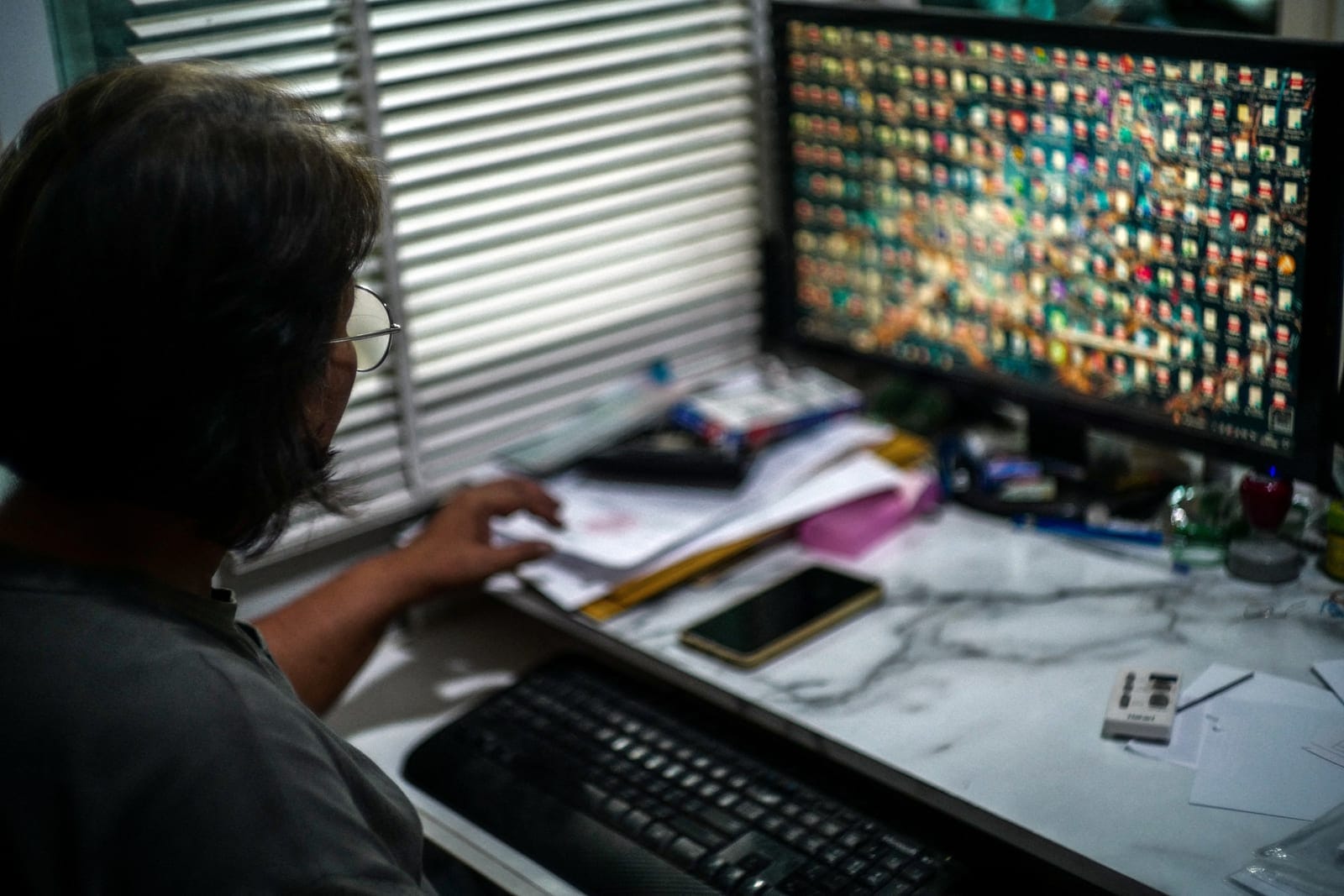 Kavita Wongyakasem, 51, a small-business owner who says she has about 10 million baht in debt, works on a computer to pay her bills at her house in Nonthaburi province on the outskirts of Bangkok, Thailand, September 23, 2026. REUTERS/Athit Perawongm