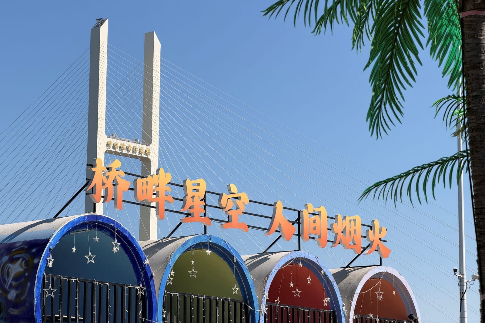 The New Yalu River Bridge, which is designed to link North Korea's Sinuiju with China's Dandong New Zone, is seen from a campsite by the Yalu River in Dandong, Liaoning province, China October 6, 2026. The sign reads, "Starry skies by the bridge, the
