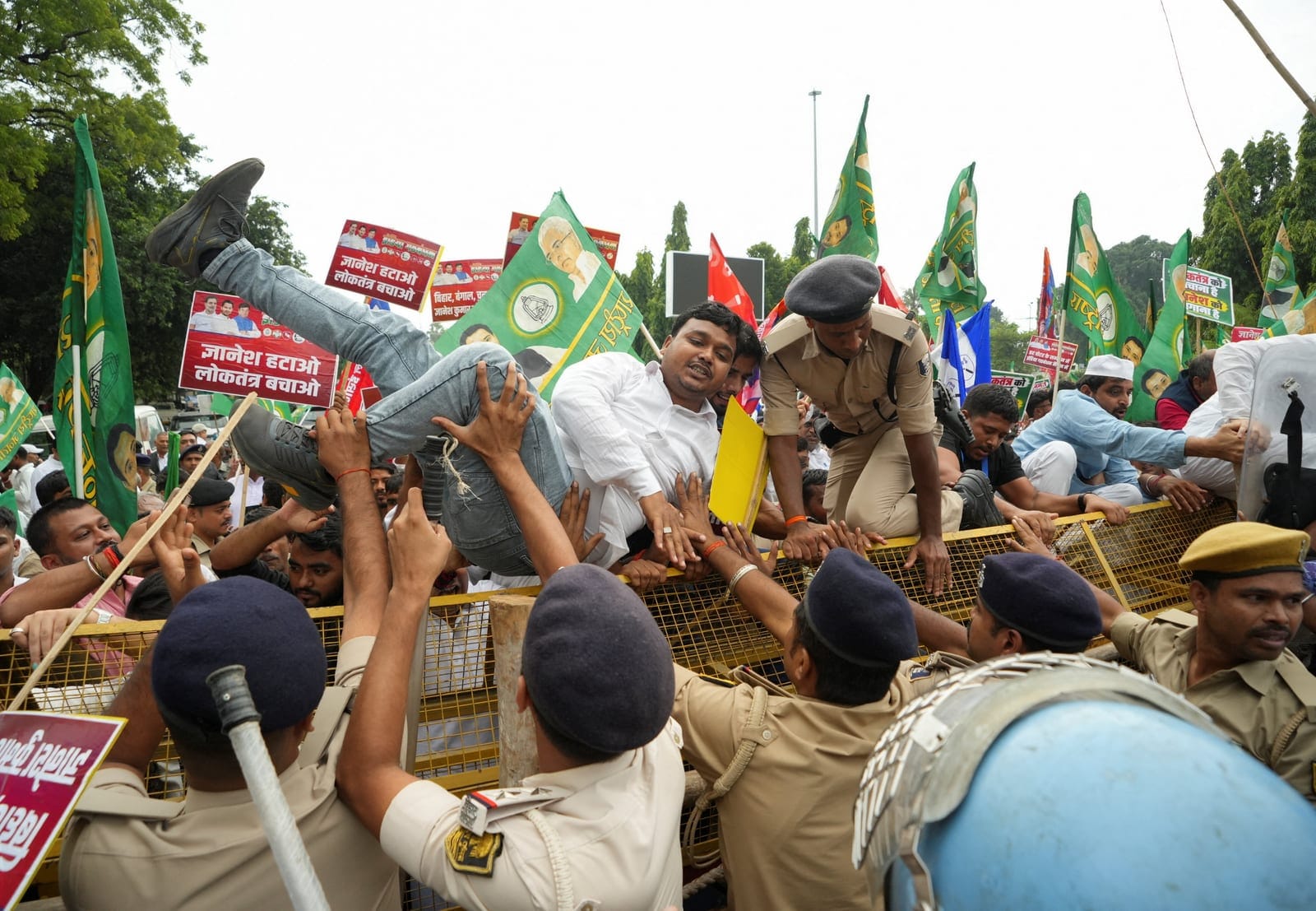 A demonstrator tries to climb through a barricade during a protest organized by opposition parties demanding the resignation of Chief Election Commissioner Gyanesh Kumar, in Patna, India, October 8, 2026. REUTERS/Sonu Kishan