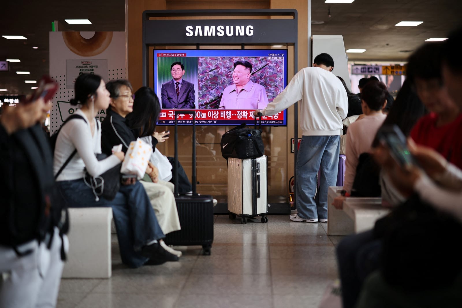 People watch a TV broadcasting a news report on North Korea firing multiple ballistic missiles toward the sea off its east coast, at a railway station in Seoul, South Korea, October 12, 2026. REUTERS/Kim Hong-Ji