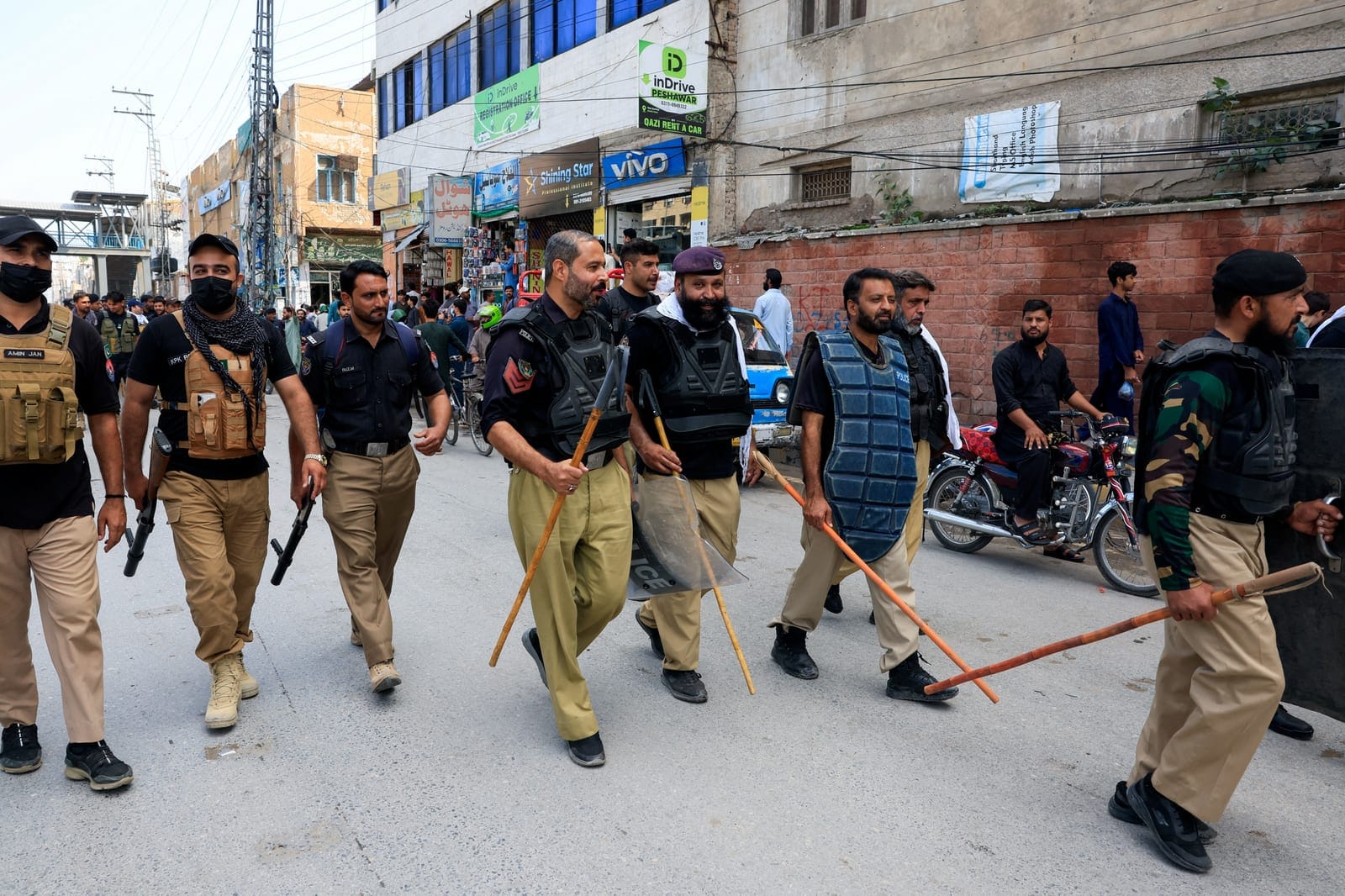 Police officers walk with riot gear as a security measure following a protest call by supporters of jailed former Pakistani Prime Minister Imran Khan's party, Pakistan Tehreek-e-Insaf (PTI), a day after Pakistan imposed a state of emergency in Khyber