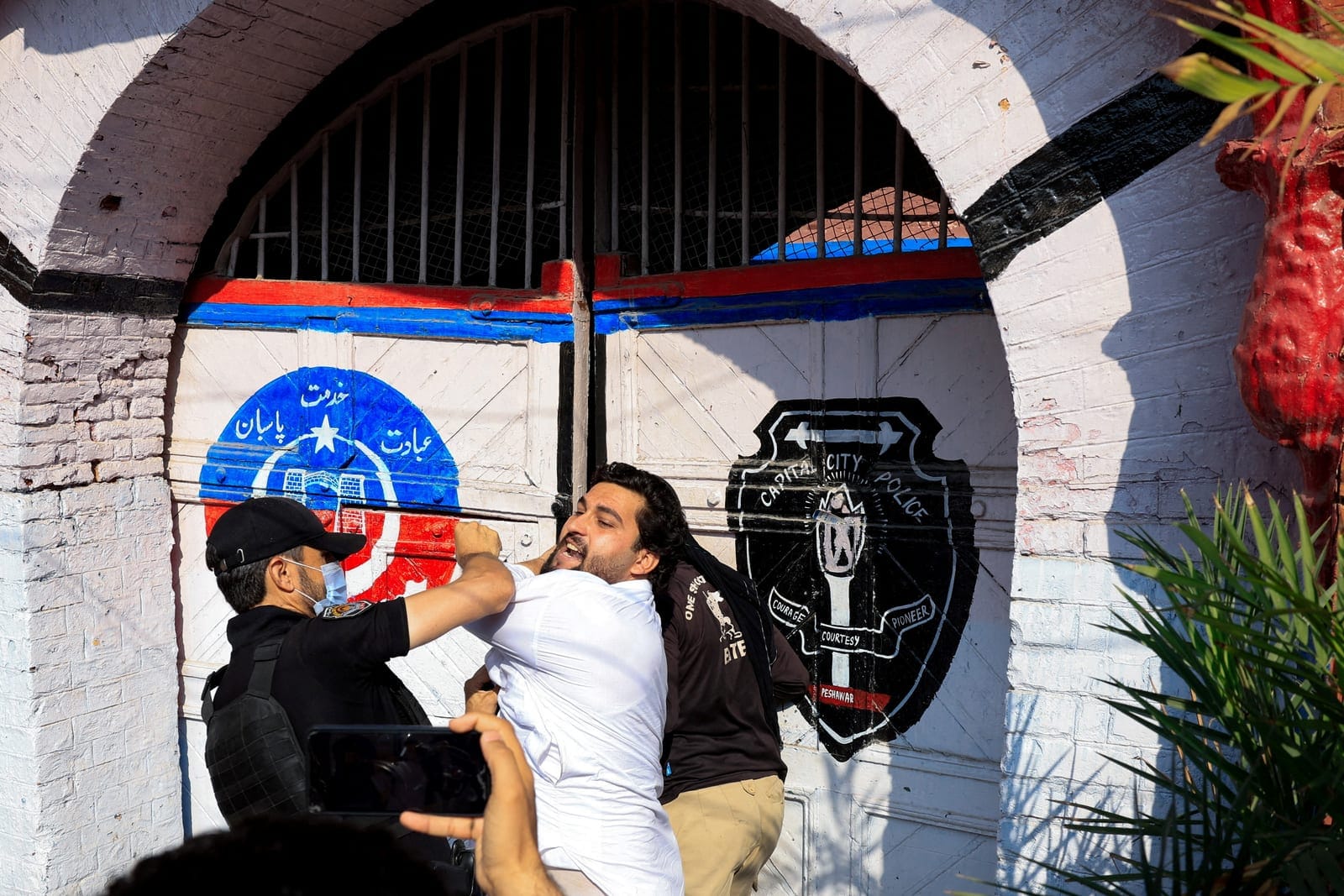 Police officers detain a protester following a protest call by supporters of jailed former Pakistani Prime Minister Imran Khan's party, Pakistan Tehreek-e-Insaf (PTI), a day after Pakistan imposed a state of emergency in Khyber Pakhtunkhwa province a