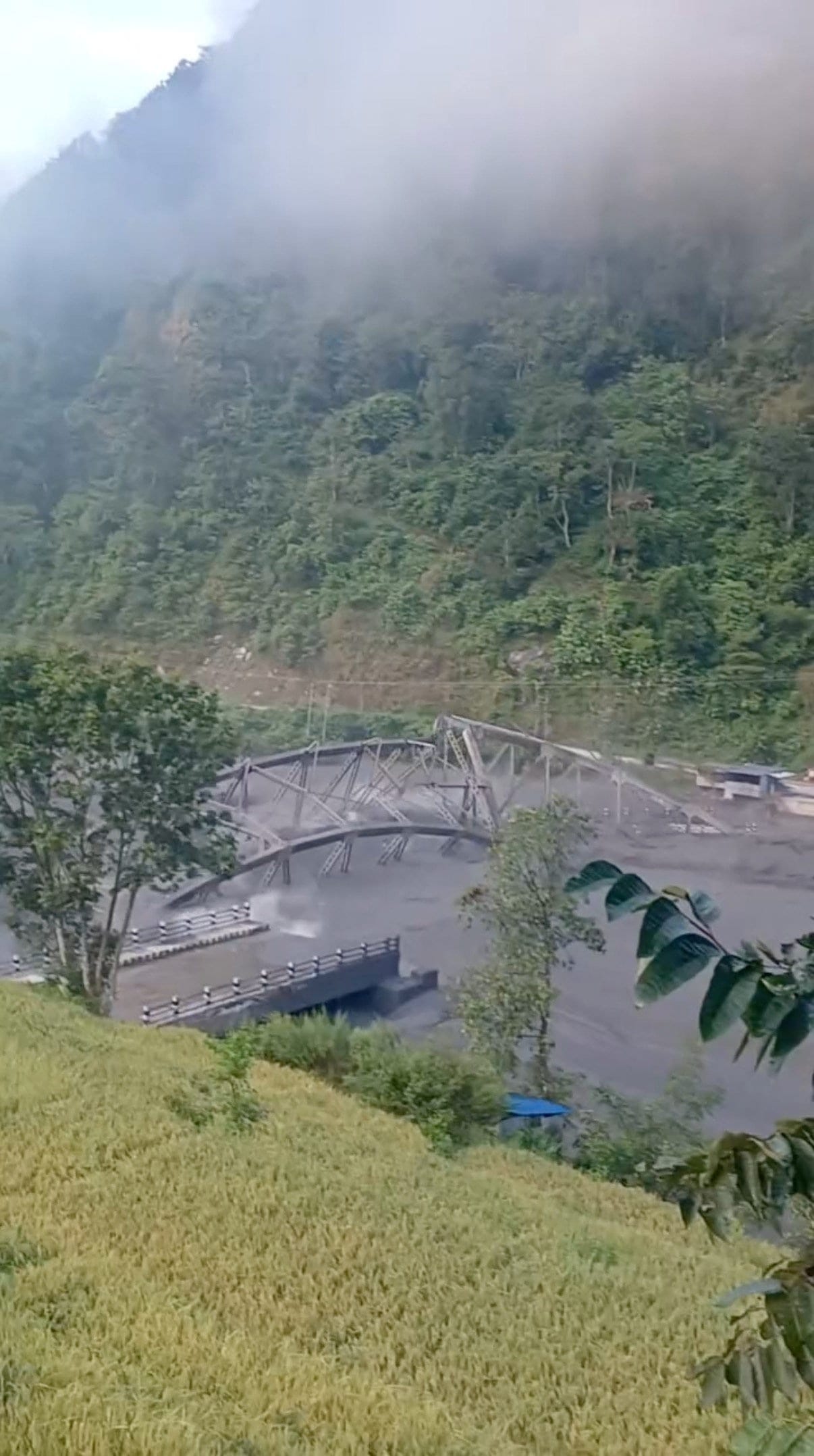 Floodwaters wash away the collapsed Soti Bridge on Budhi Gandaki River, following a dry landslide in Chumnubri village, in Gorkha District, Nepal, October 11, 2026, in this screengrab obtained from a social media video. @_______bmadans via Instagram/