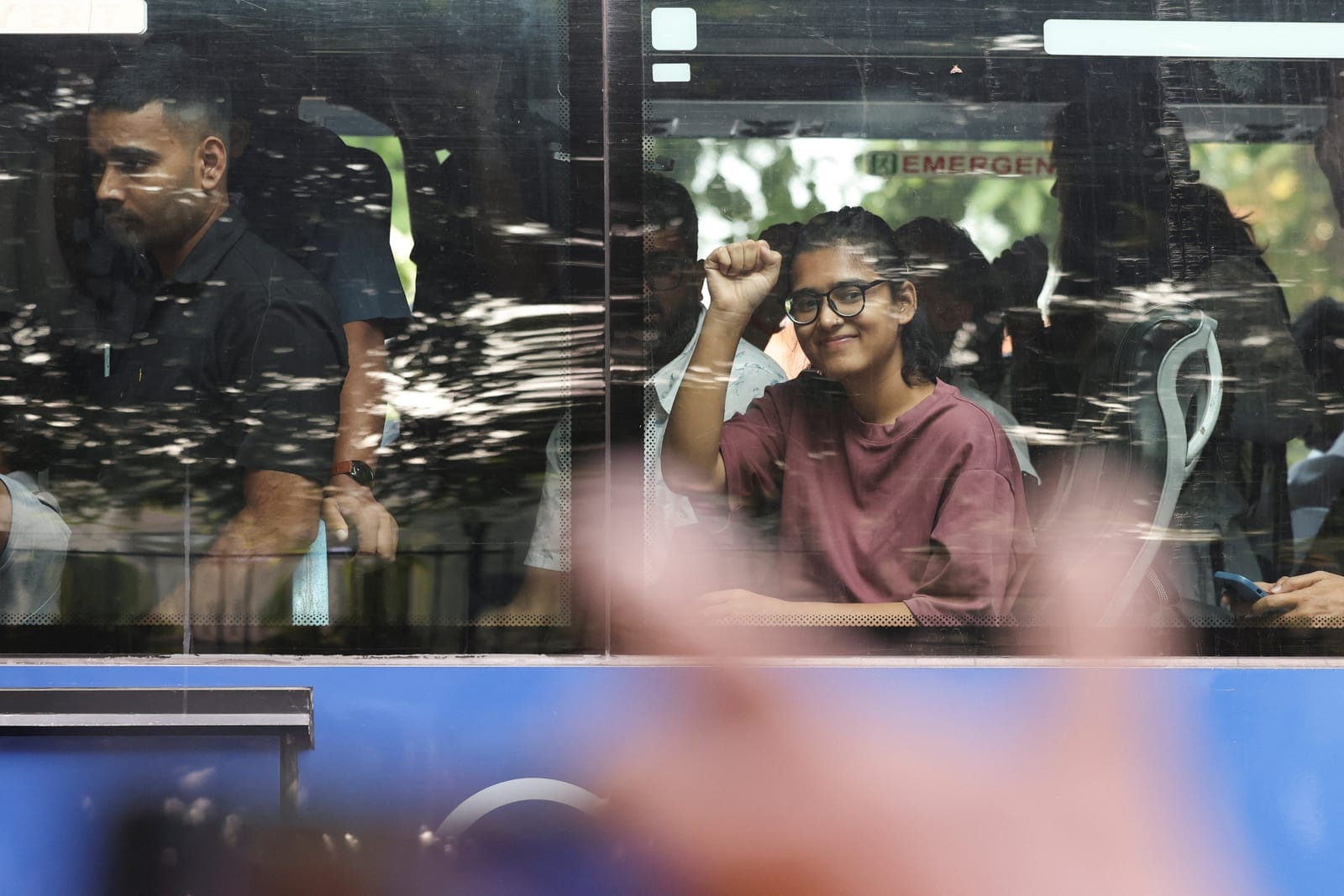 Neha Bora, national president of the All India Students' Association (AISA) raises her fist while sitting inside a bus, as opposition parties march to the Supreme Court in protest against a controversial revision of voter lists that has sparked days 