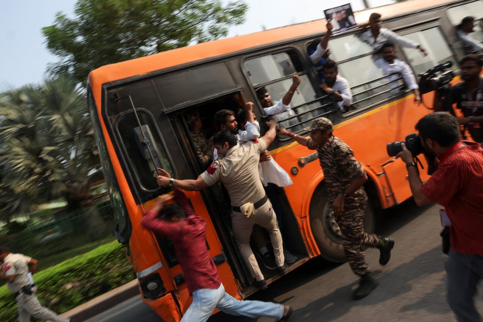 Security personnel try to prevent detained protesters from escaping from a bus during a protest demanding the resignation of India's Chief Election Commissioner, Gyanesh Kumar, in New Delhi, India, October 13, 2026. REUTERS/Priyanshu Singh