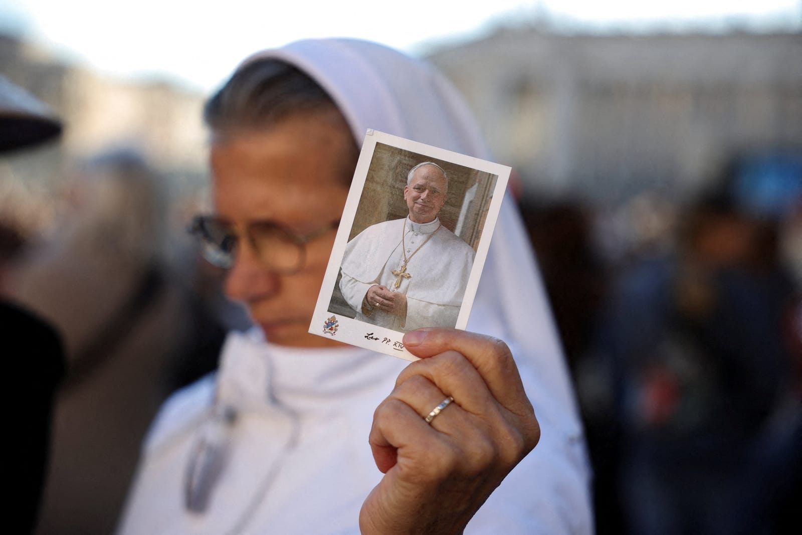 A person holds a picture of Pope Leo on the day of a mass marking the 10th anniversary of the apostolic exhortation Amoris Laetitia, including special prayers for the health of Pope Leo, who is in a hospital after lung surgery, in St. Peter's Square