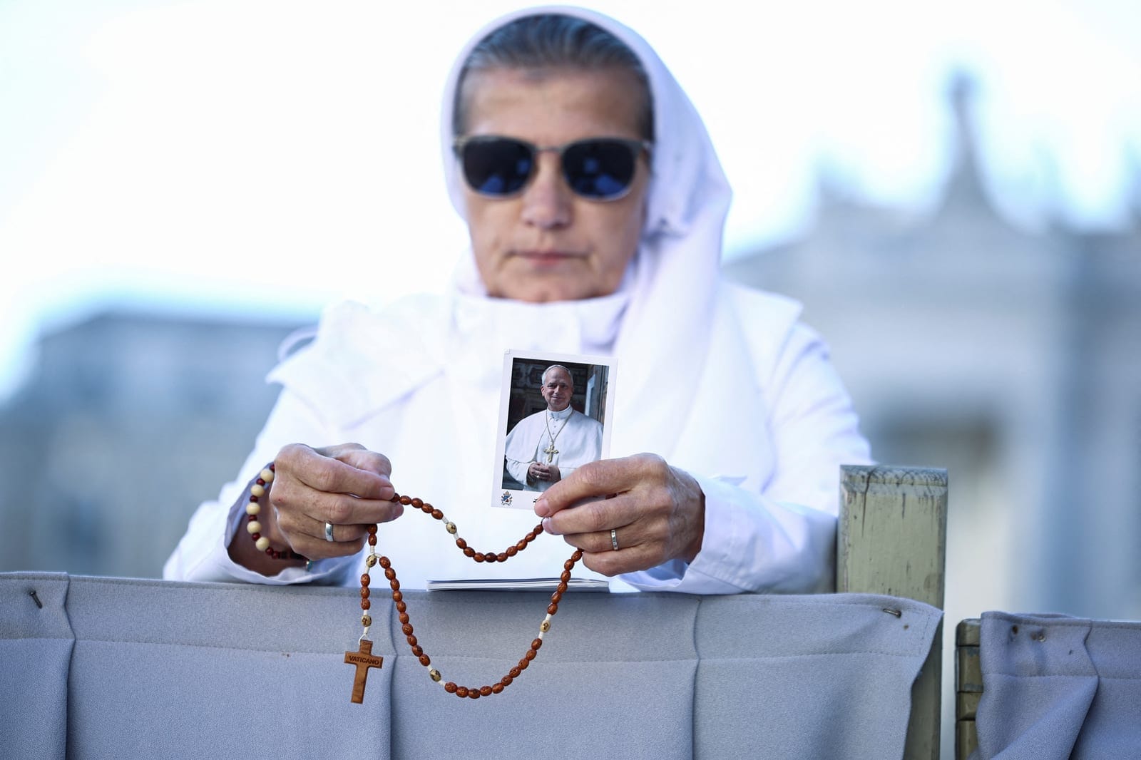 A nun holds a picture of Pope Leo on the day of a mass marking the 10th anniversary of the apostolic exhortation Amoris Laetitia, including special prayers for the health of Pope Leo, who is in a hospital after lung surgery, in St. Peter's Square at